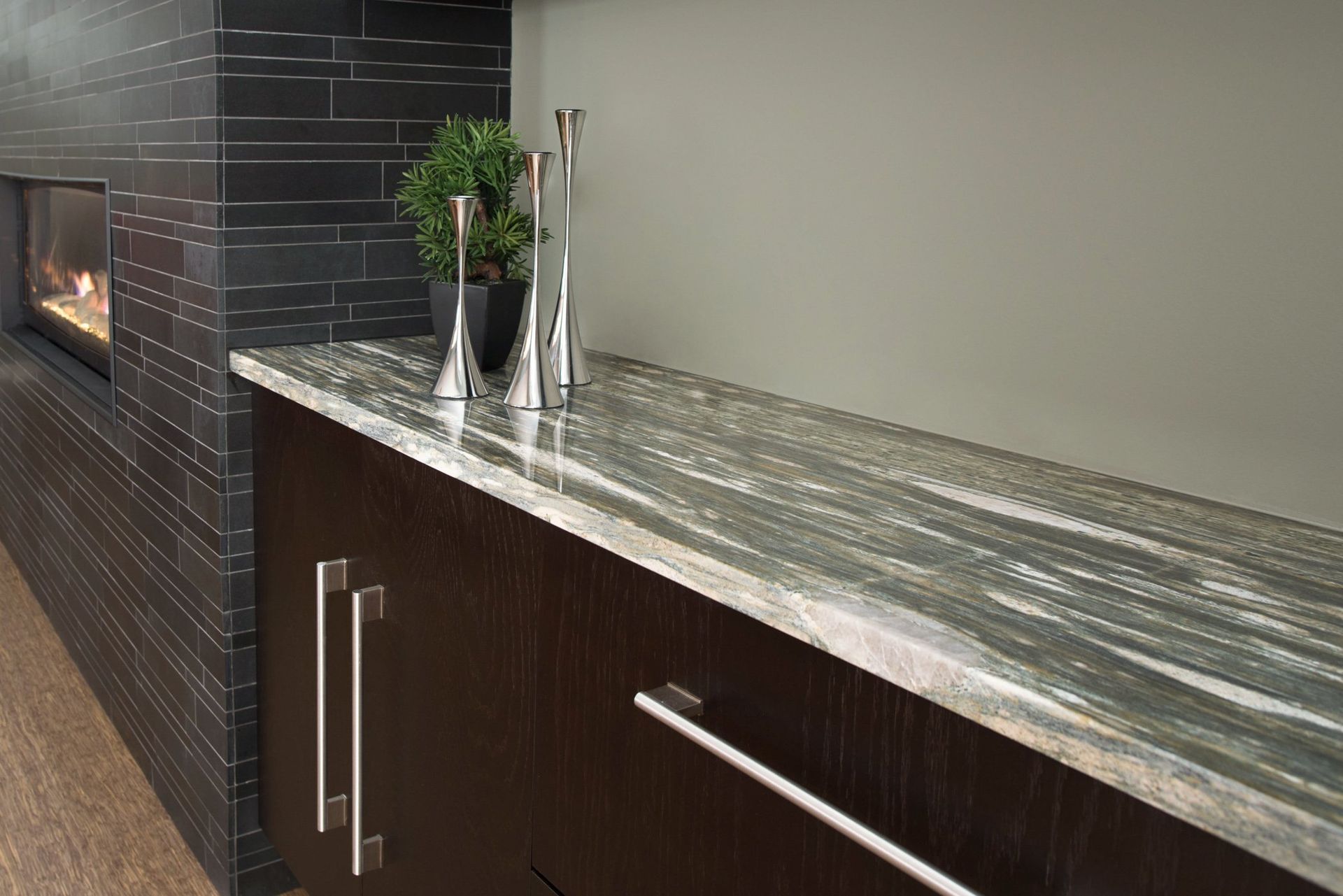 A kitchen counter with a plant on it and a fireplace in the background.