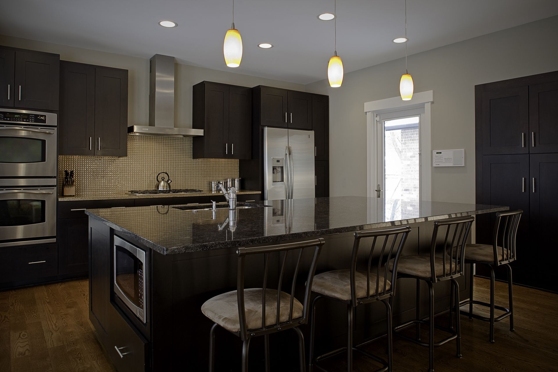 A kitchen with stainless steel appliances and black cabinets