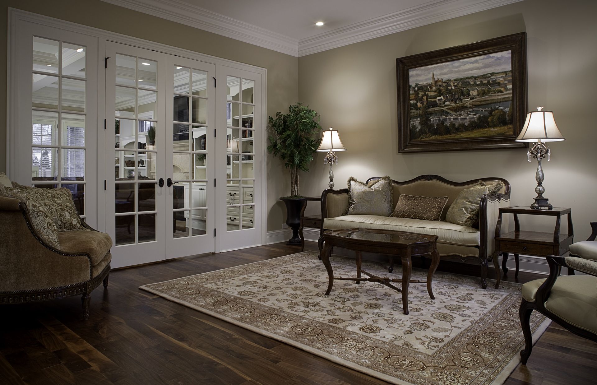 A living room with a couch , chairs , lamps and a rug