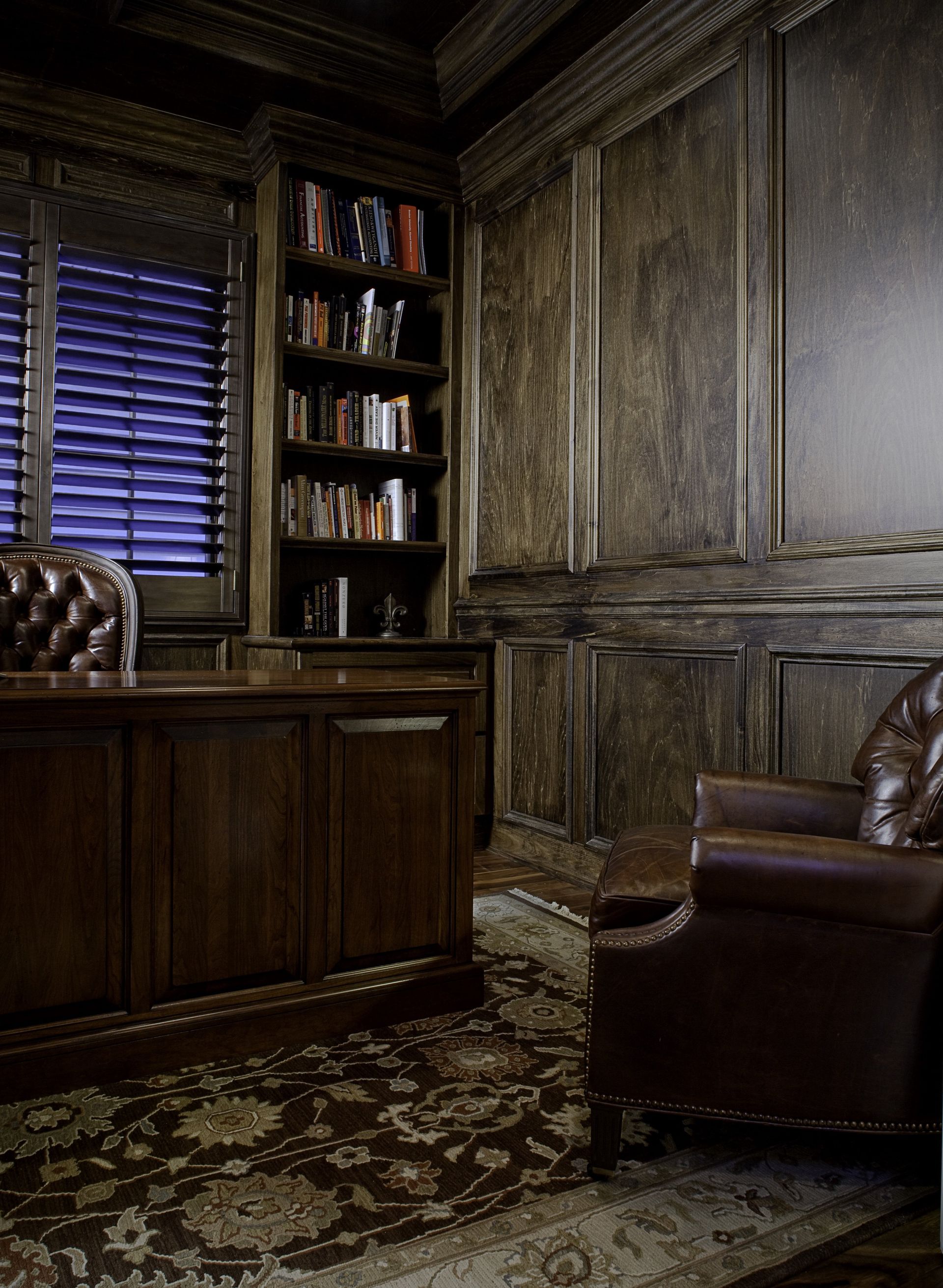 A dark room with a desk and a chair