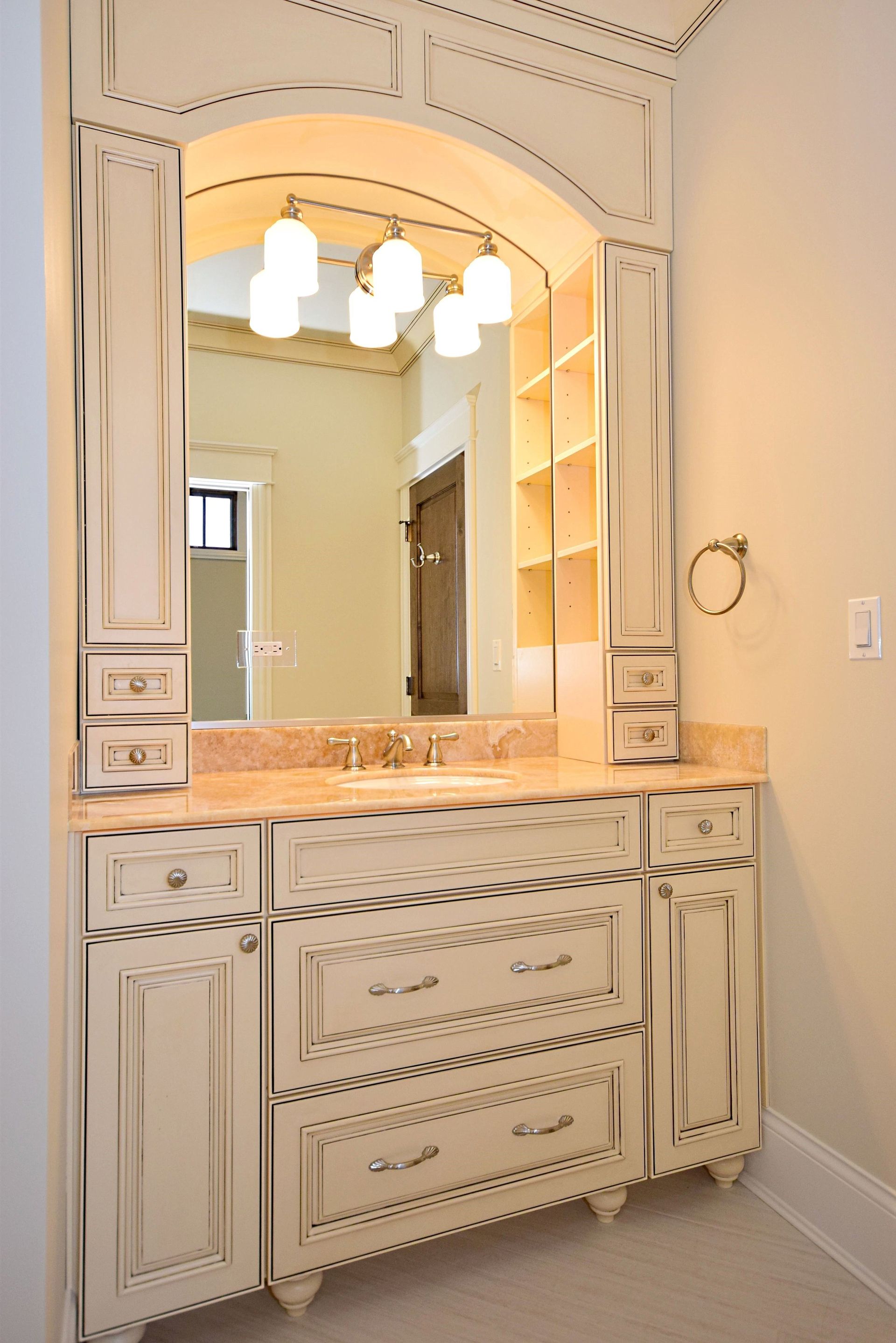 A bathroom with white cabinets and a large mirror