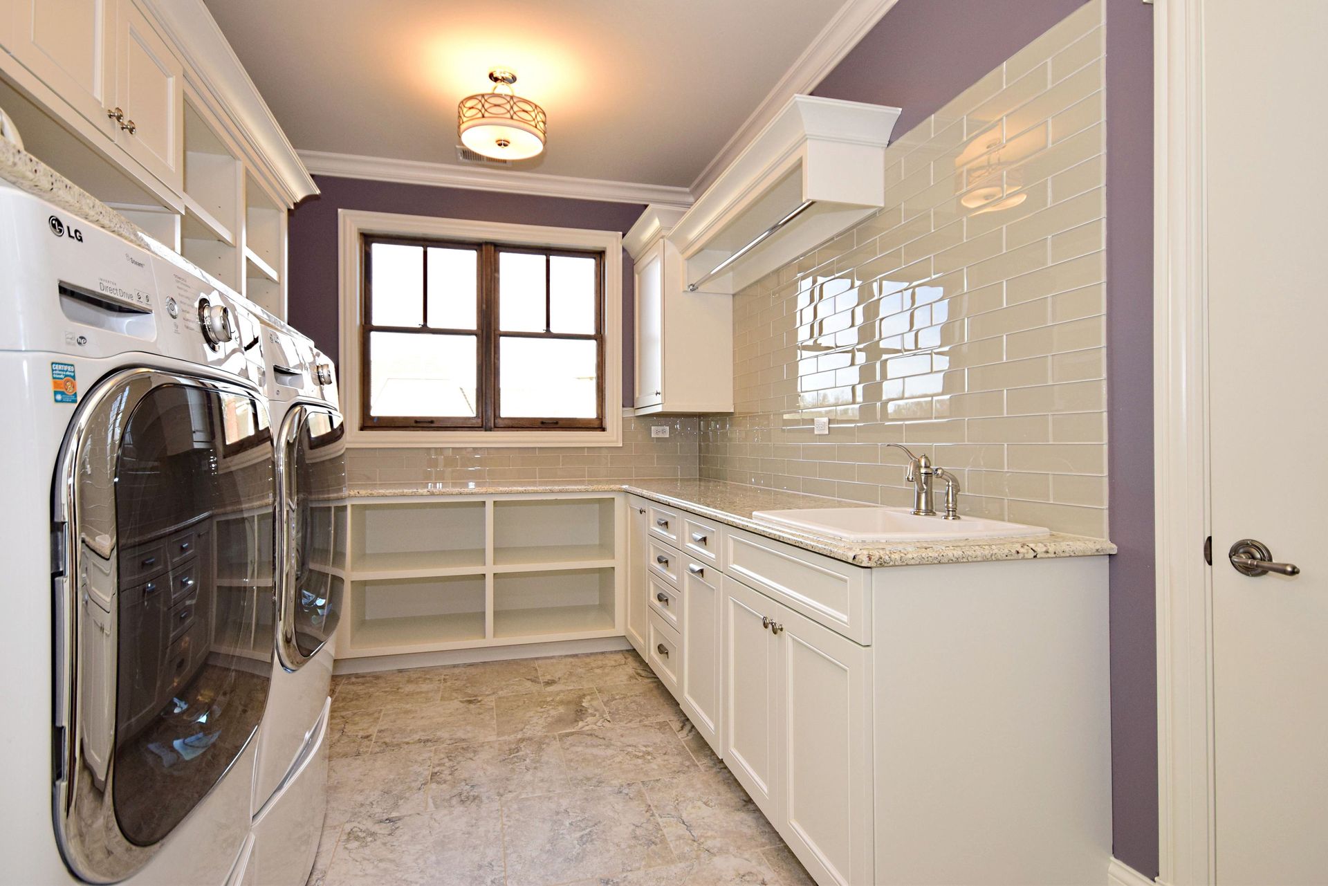 A laundry room with a washer and dryer and a sink.