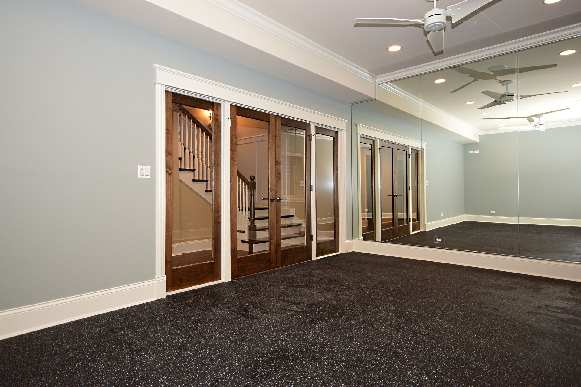 A room with a lot of mirrors and a ceiling fan