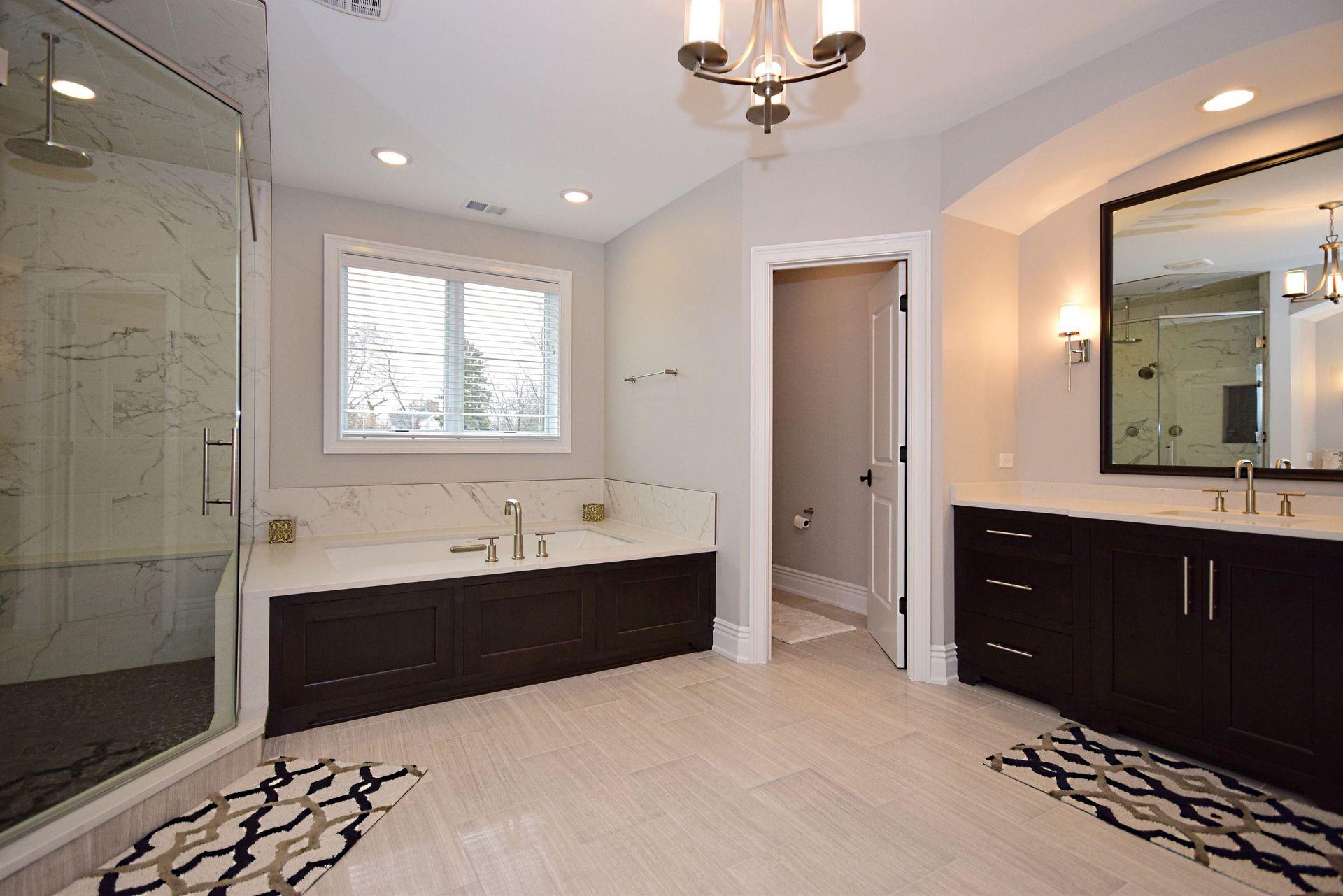 A bathroom with two sinks a tub and a shower