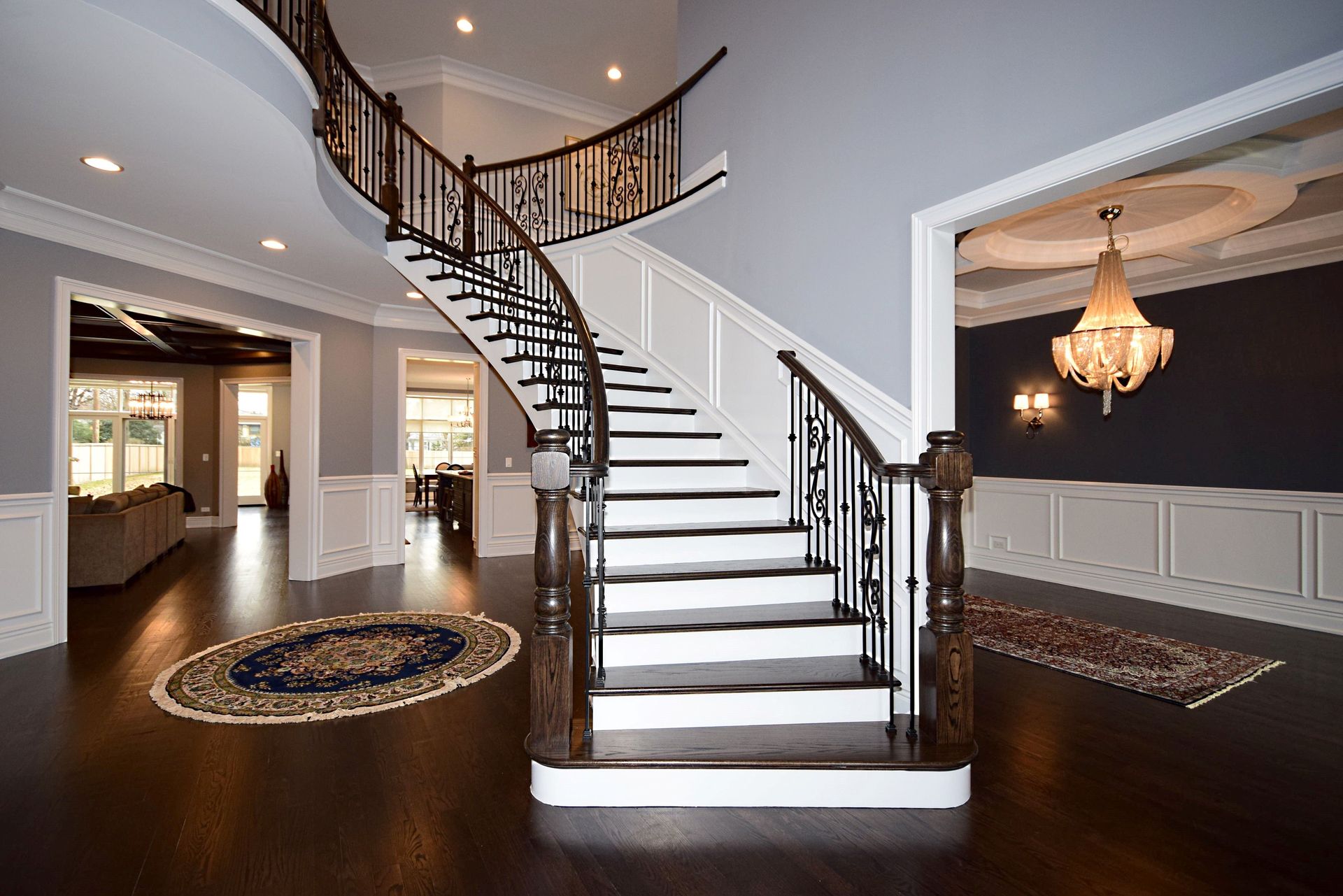 A large house with a curved staircase and a chandelier.