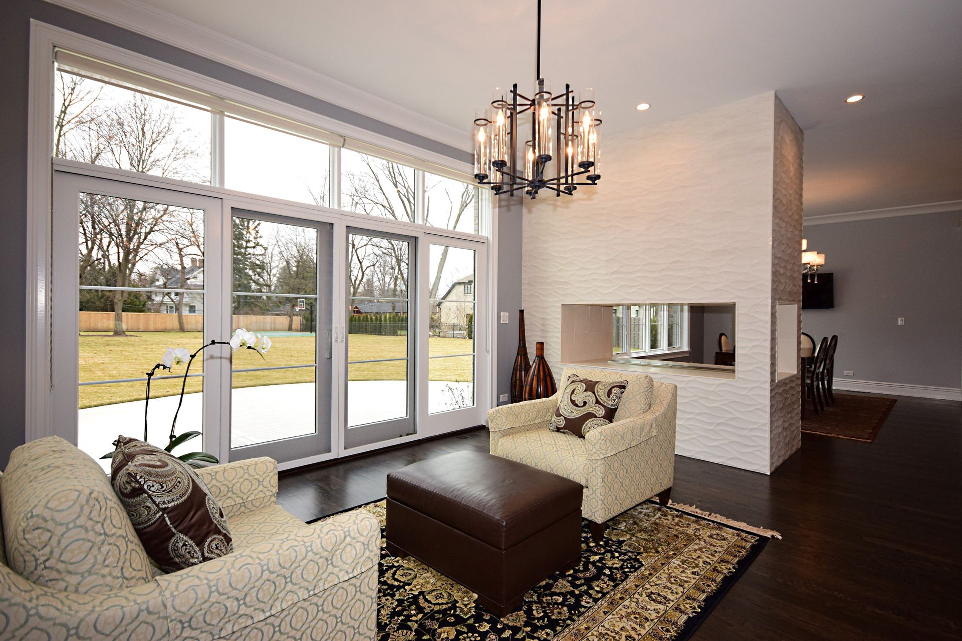 A living room with a lot of windows and a chandelier