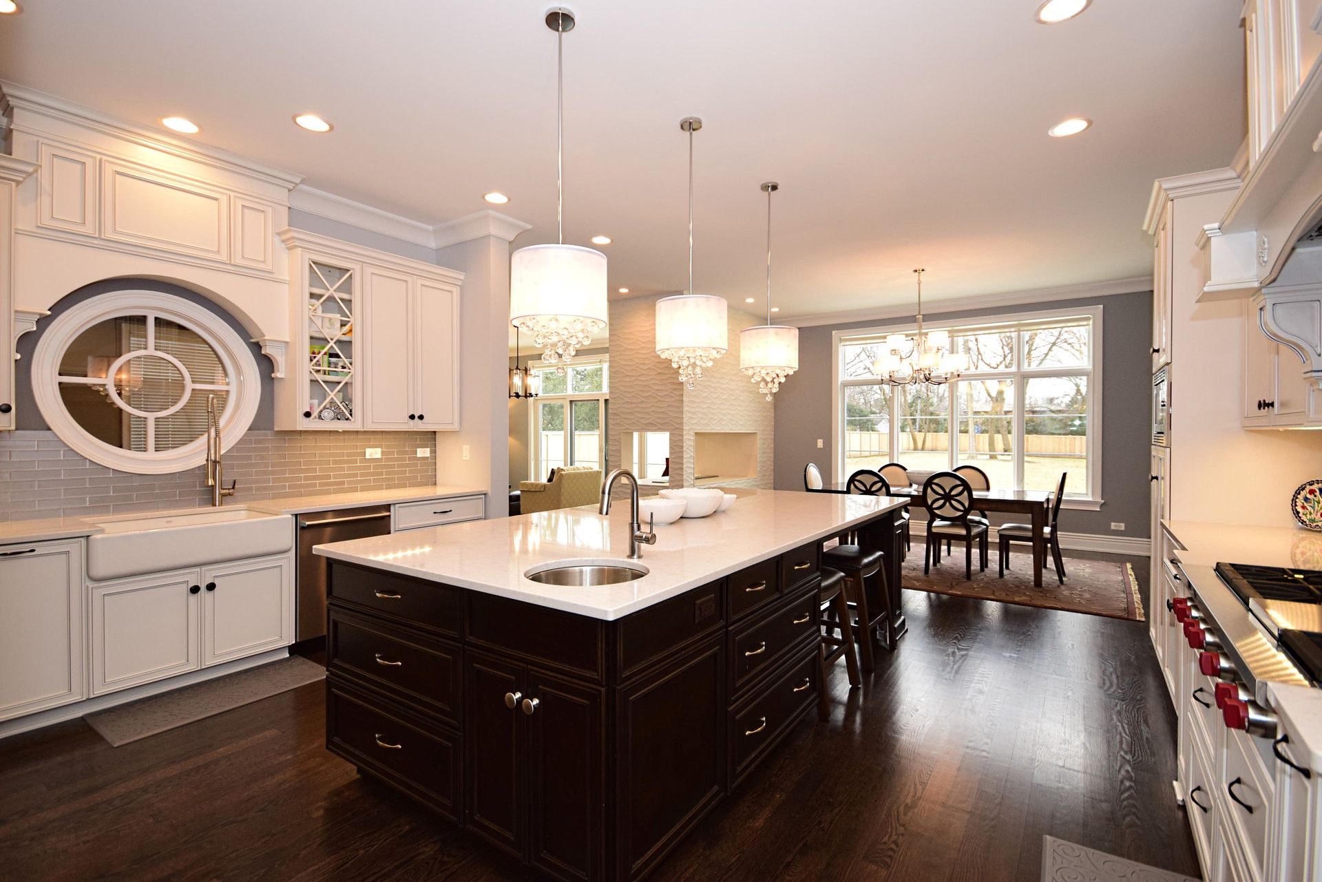 A kitchen with white cabinets and a large island in the middle.
