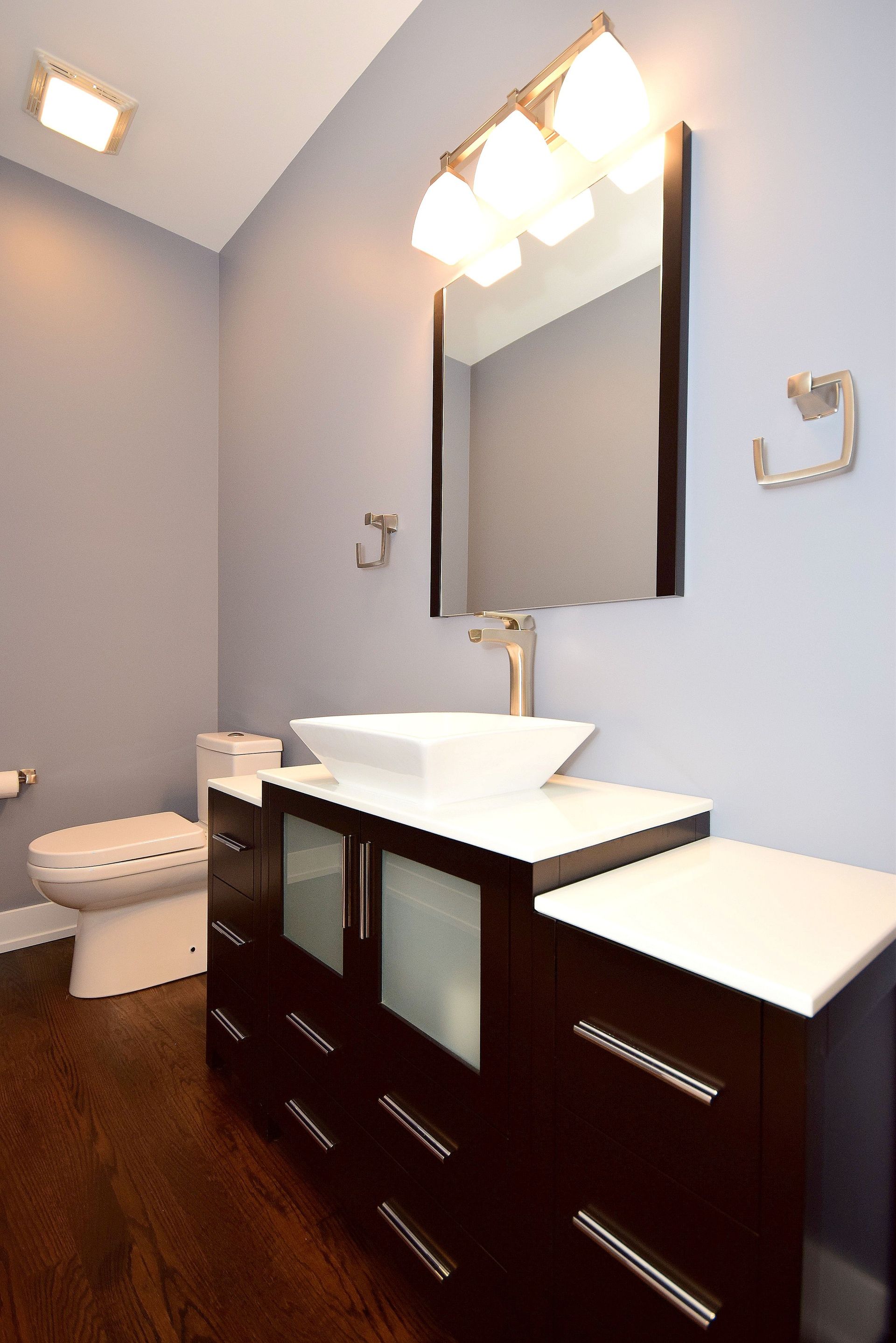 A bathroom with a toilet a sink and a mirror