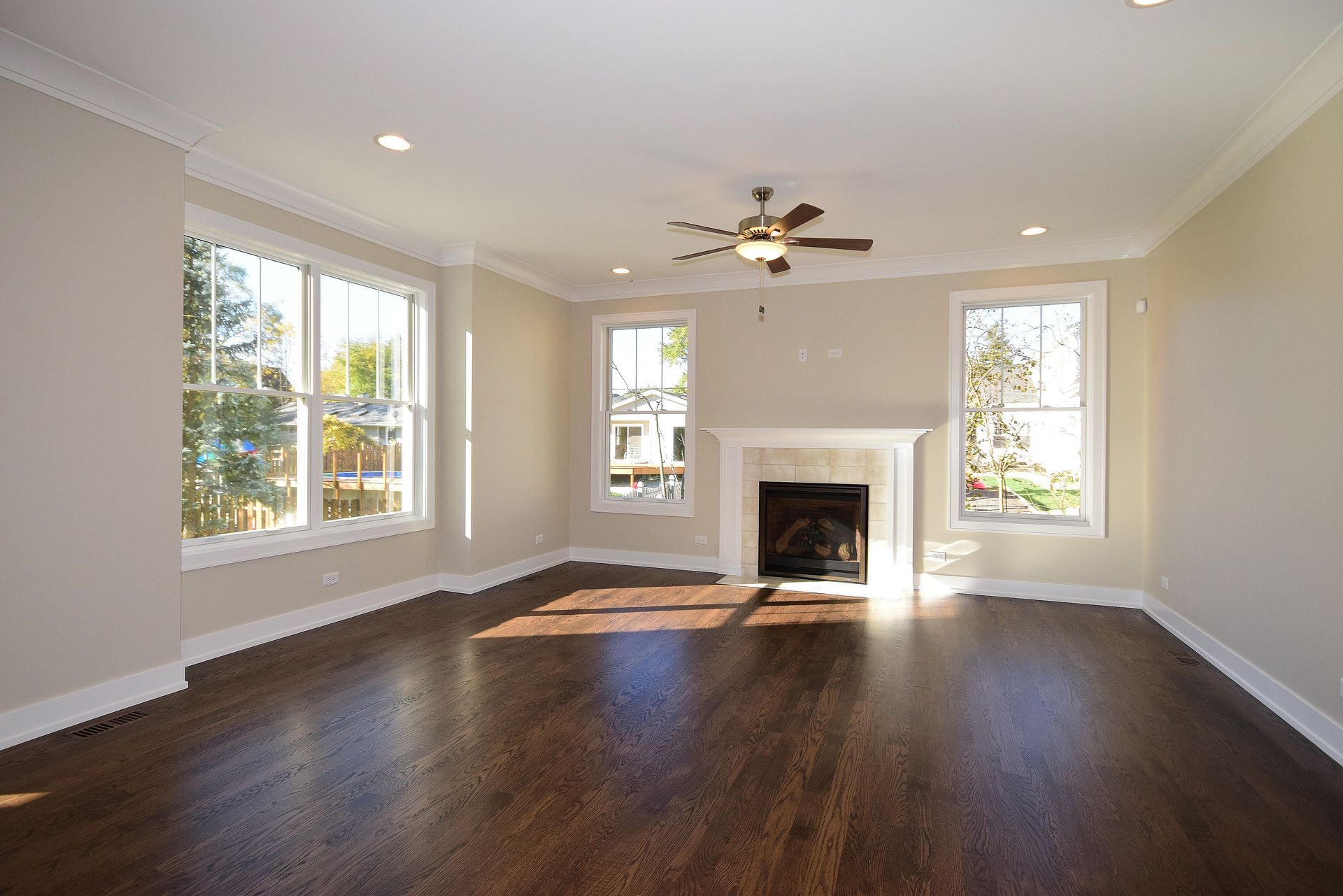 An empty living room with hardwood floors and a fireplace
