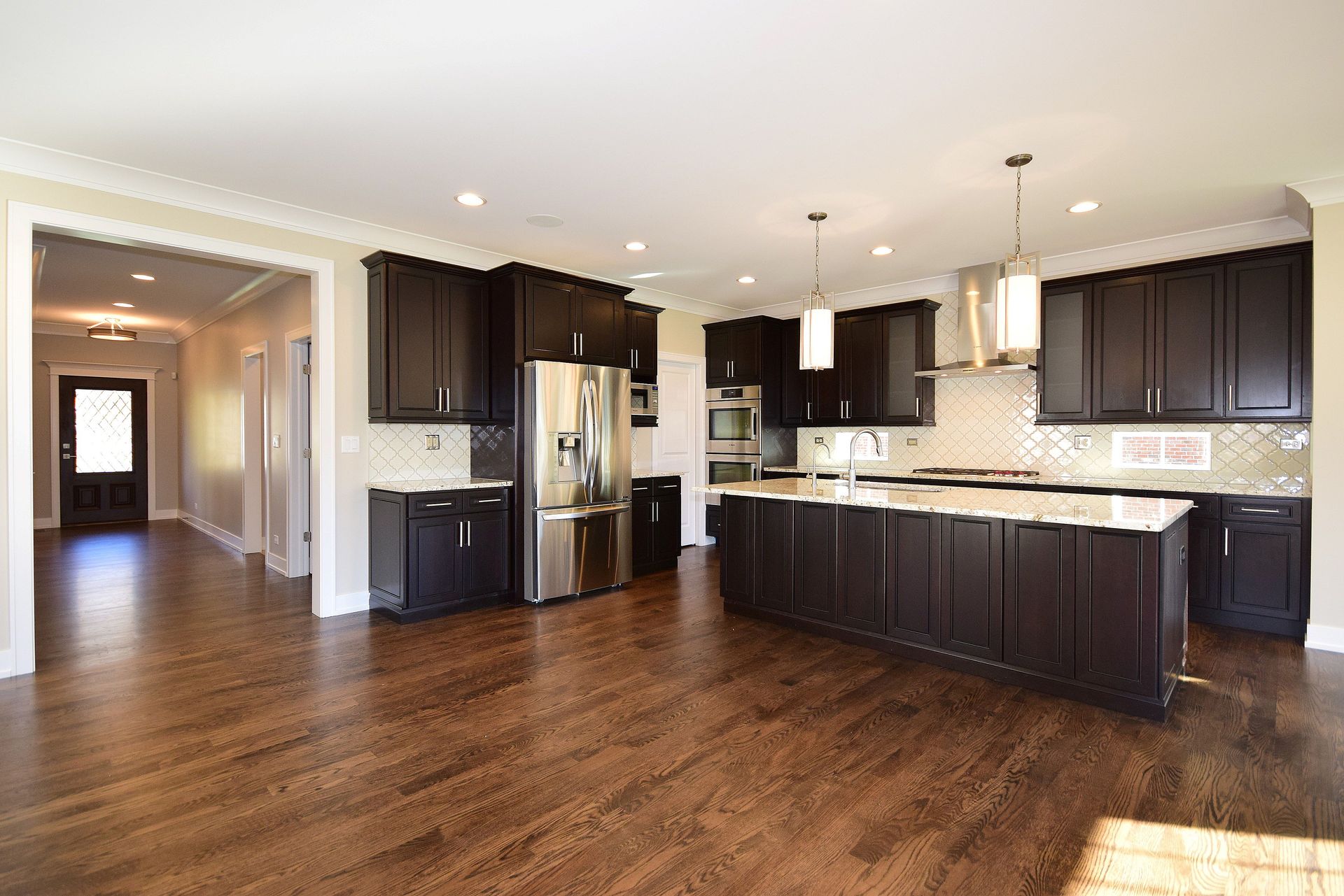 A large kitchen with dark wood cabinets and stainless steel appliances.