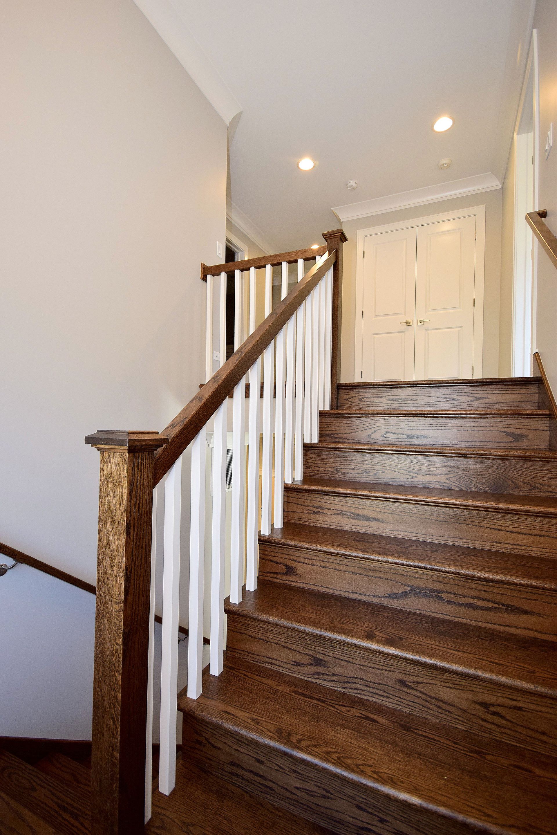A wooden staircase with a white railing in a house