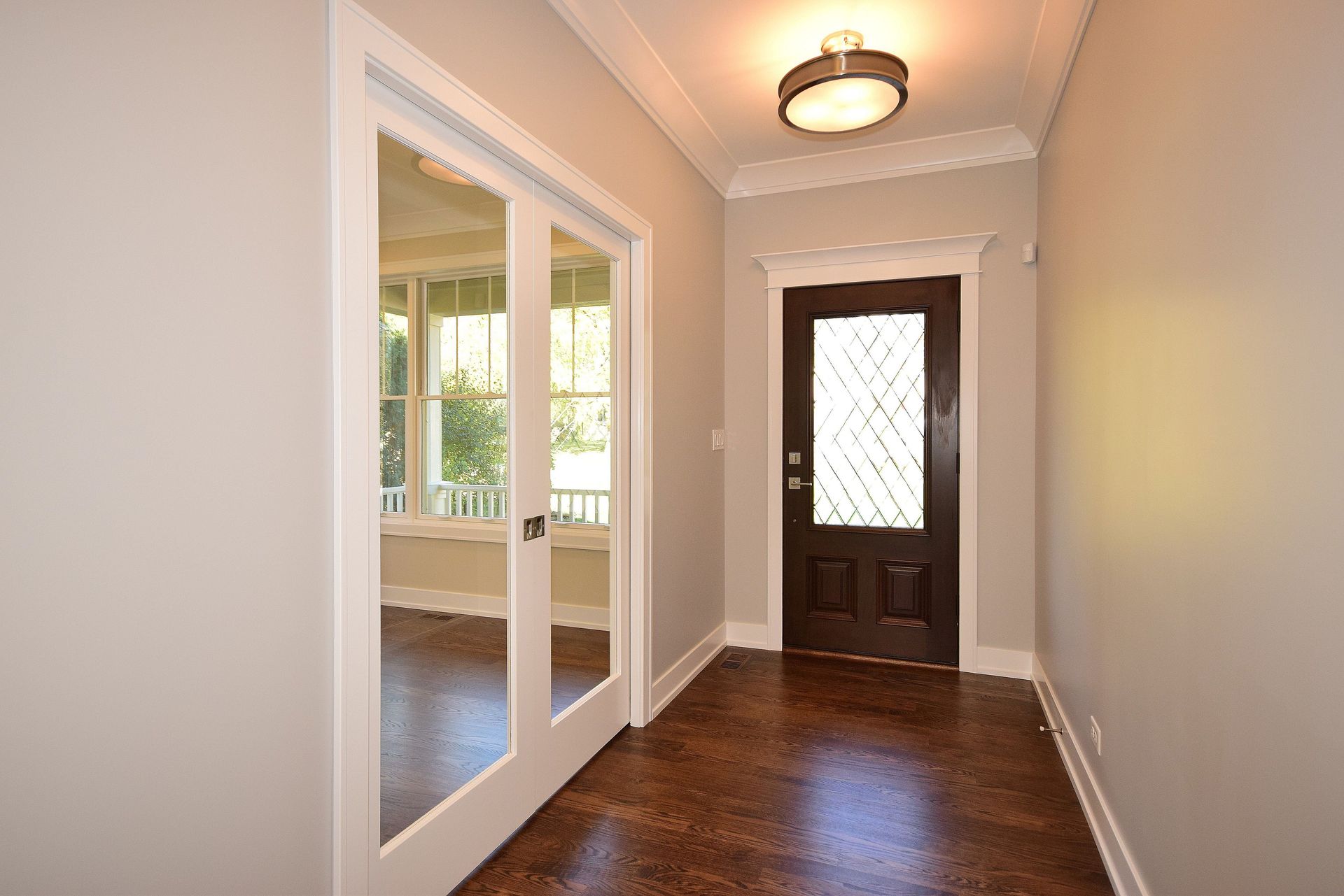 An empty hallway with a door and mirrors