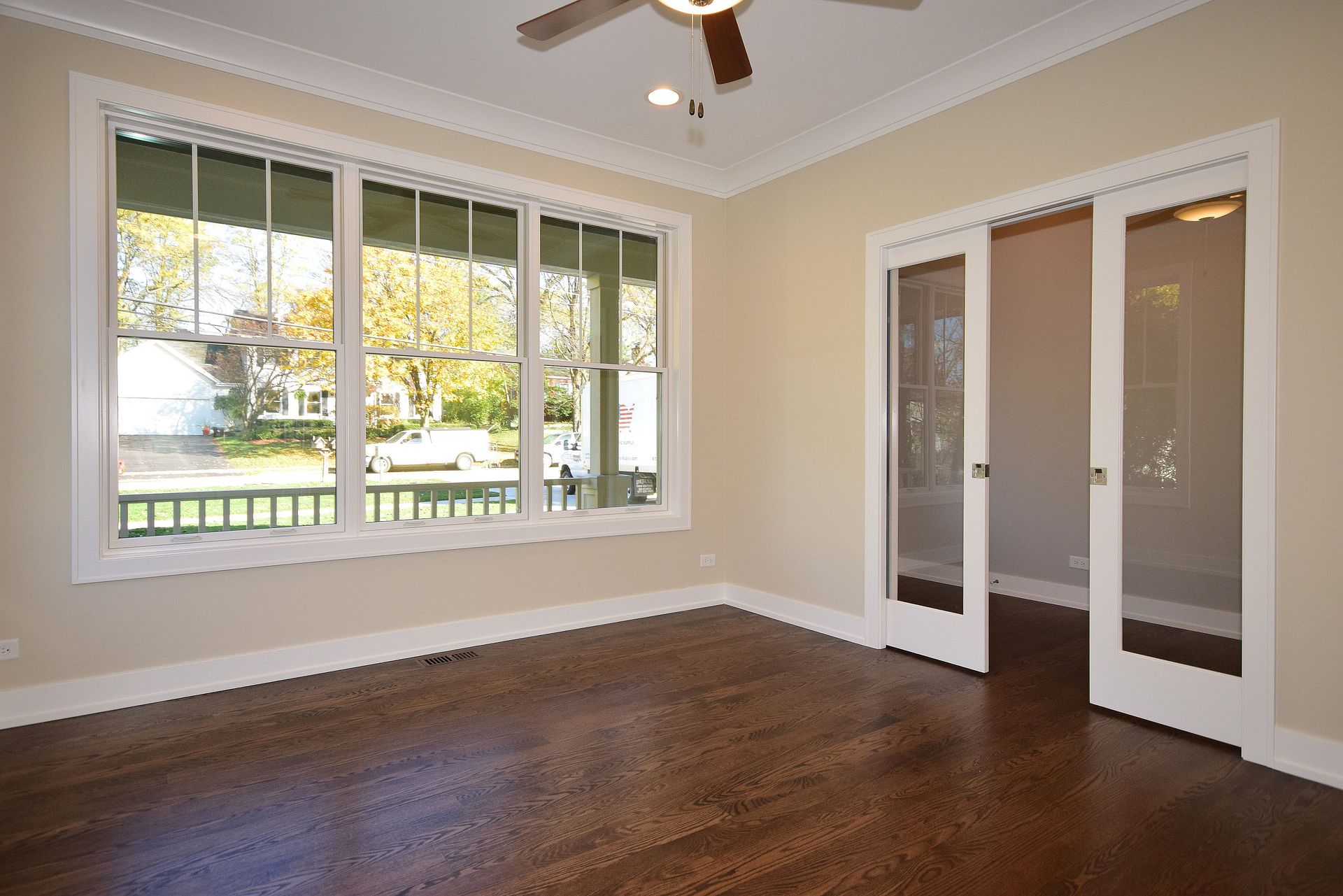 A room with a lot of windows and a ceiling fan