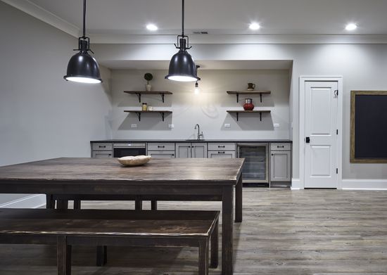 A kitchen with a table and benches and a chalkboard