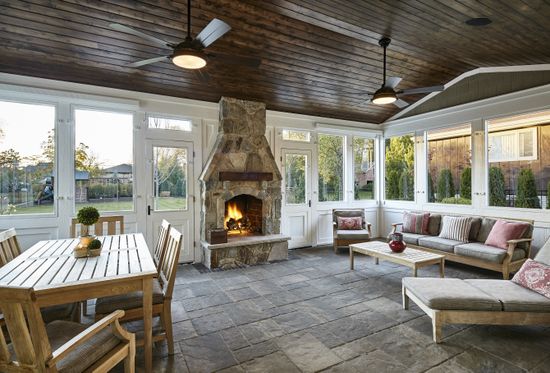 A living room with a fireplace , couch , table and chairs.