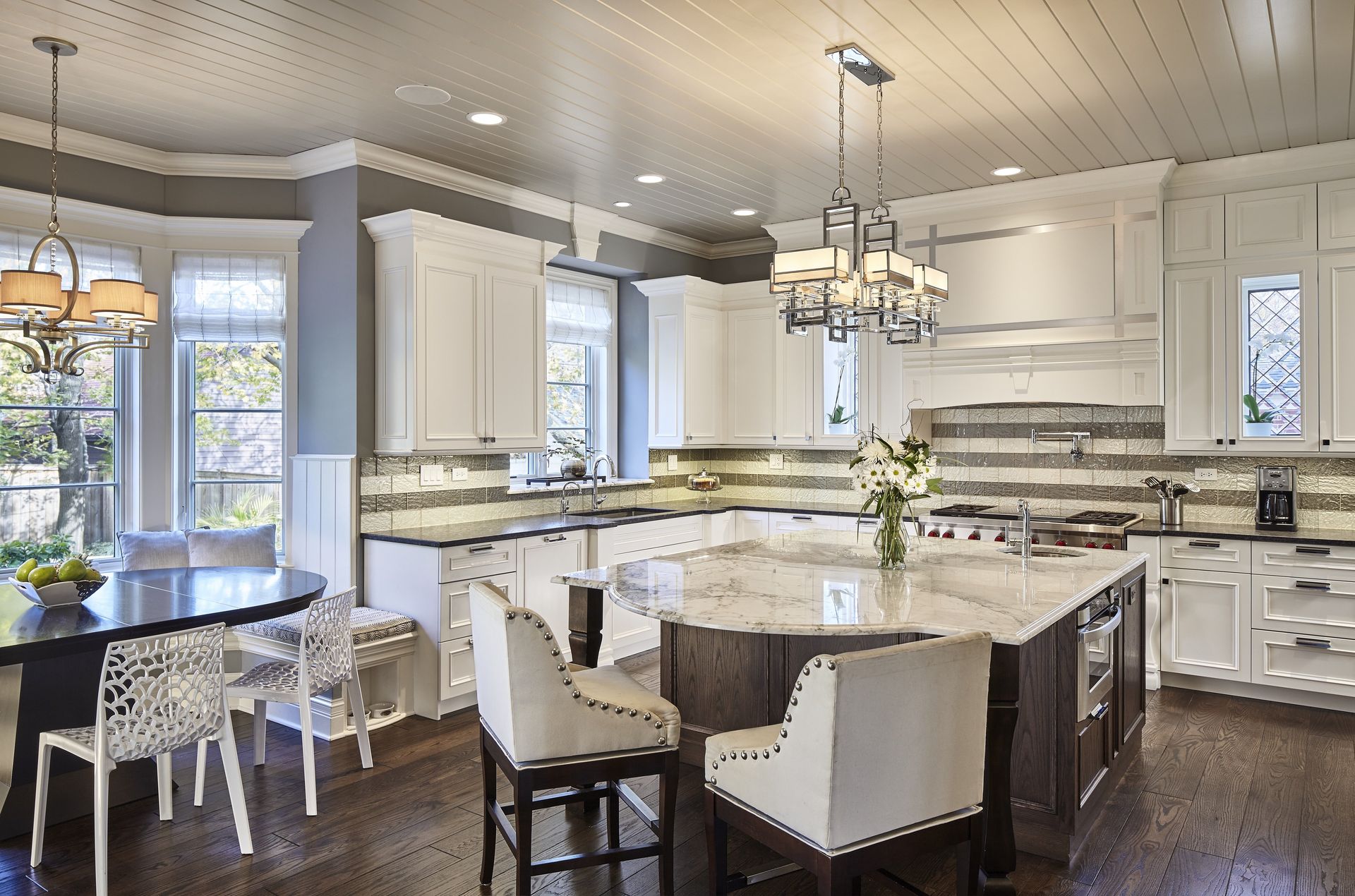 A kitchen with white cabinets and a large island in the middle