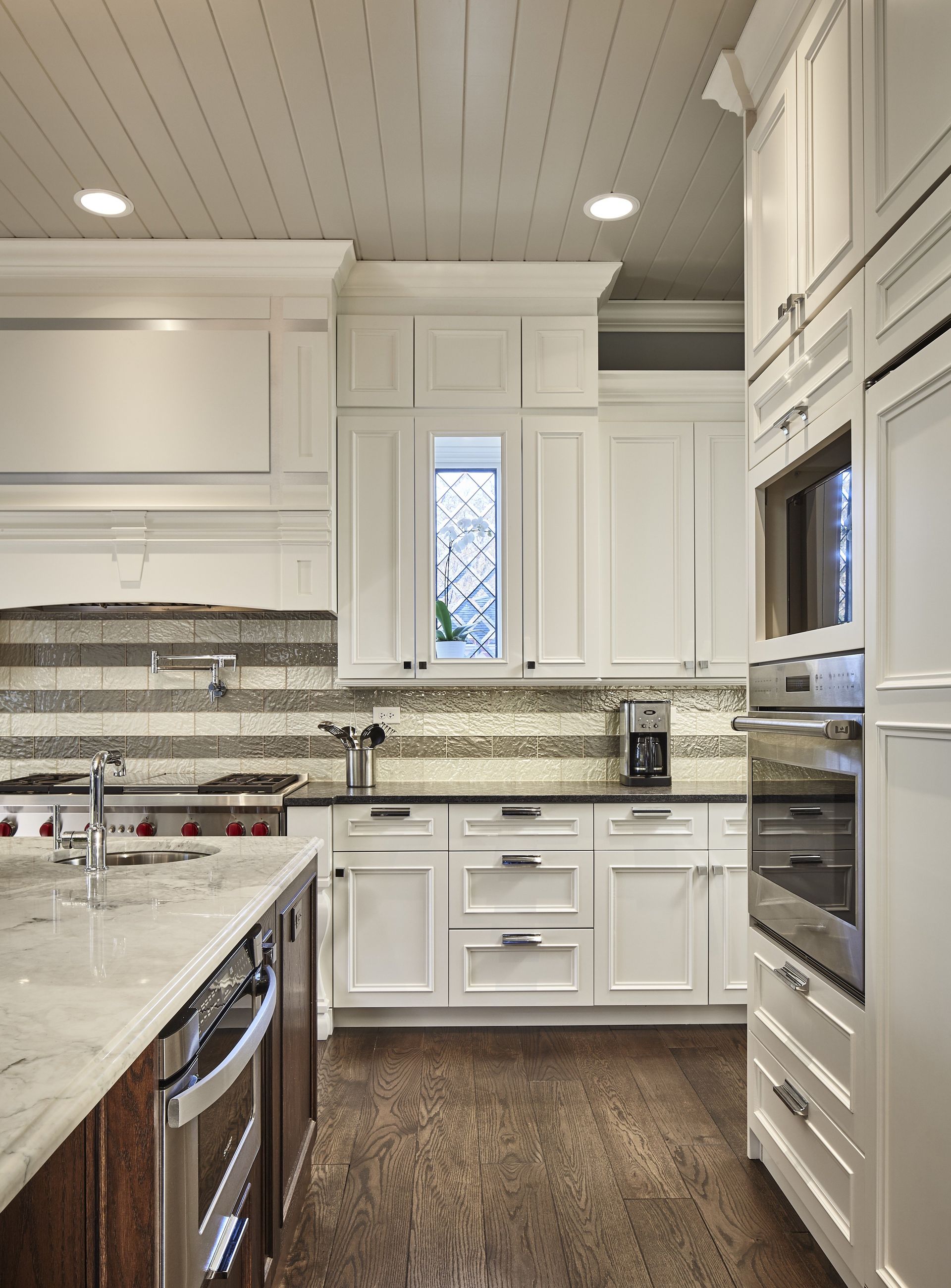 A kitchen with white cabinets and stainless steel appliances
