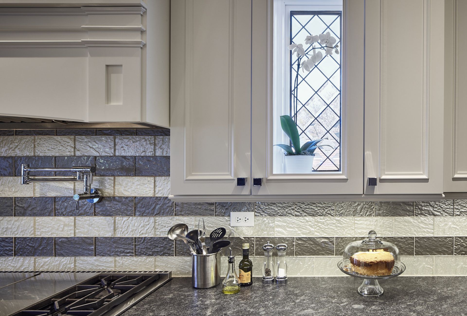 A kitchen with a stove and a cake on the counter.