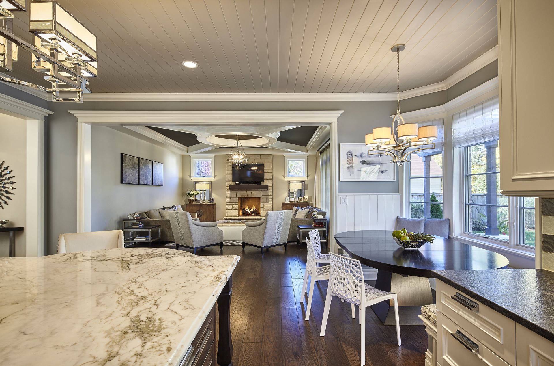 A kitchen with a marble counter top and a dining table and chairs