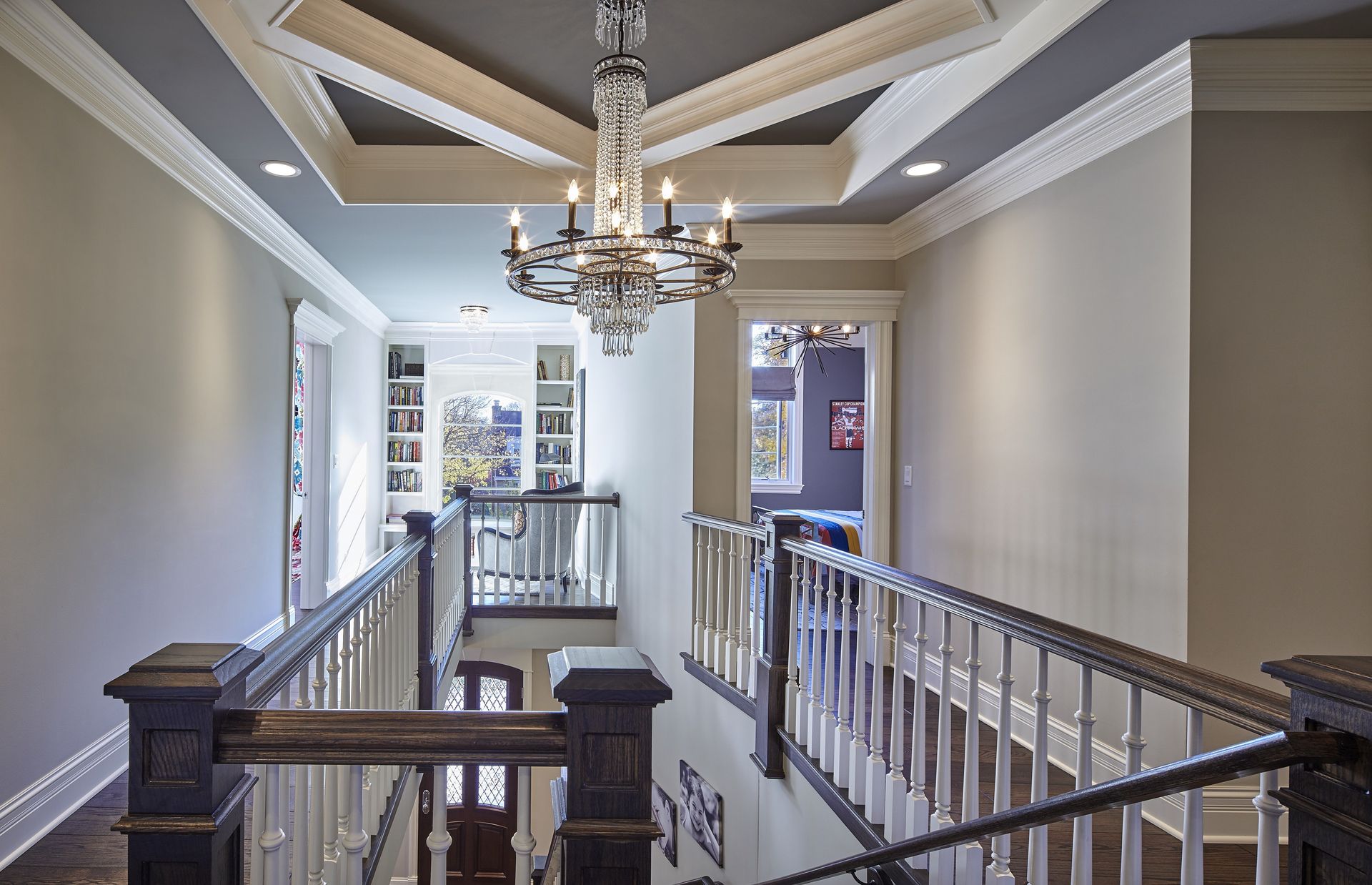 A staircase in a house with a chandelier hanging from the ceiling
