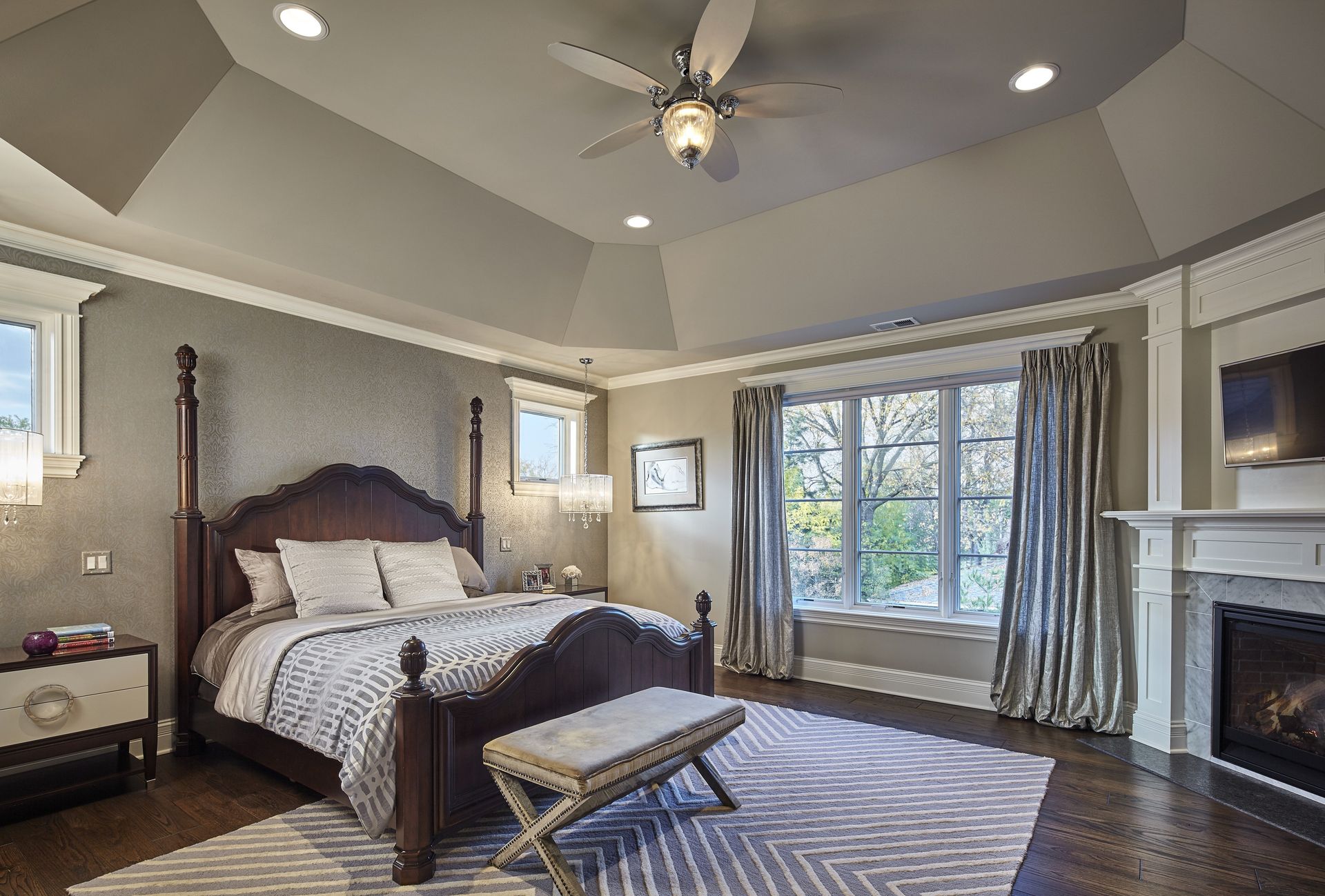 A bedroom with a large bed and a ceiling fan