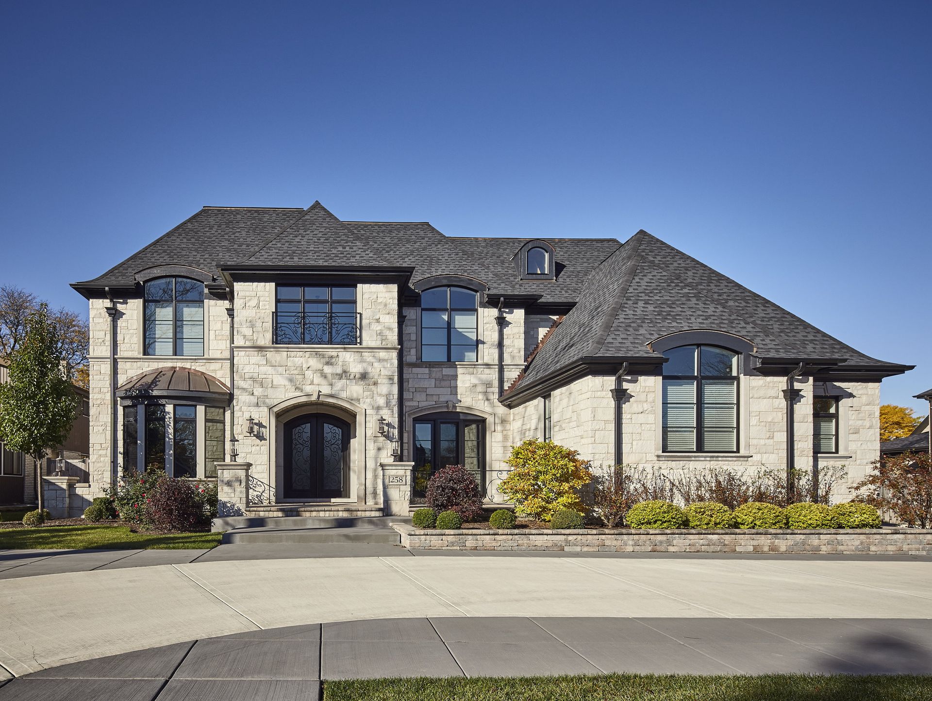 A large brick house with a black roof and a lot of windows.