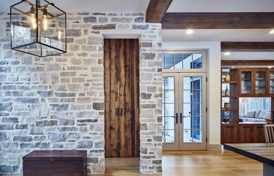 A kitchen with a brick wall and a wooden door.