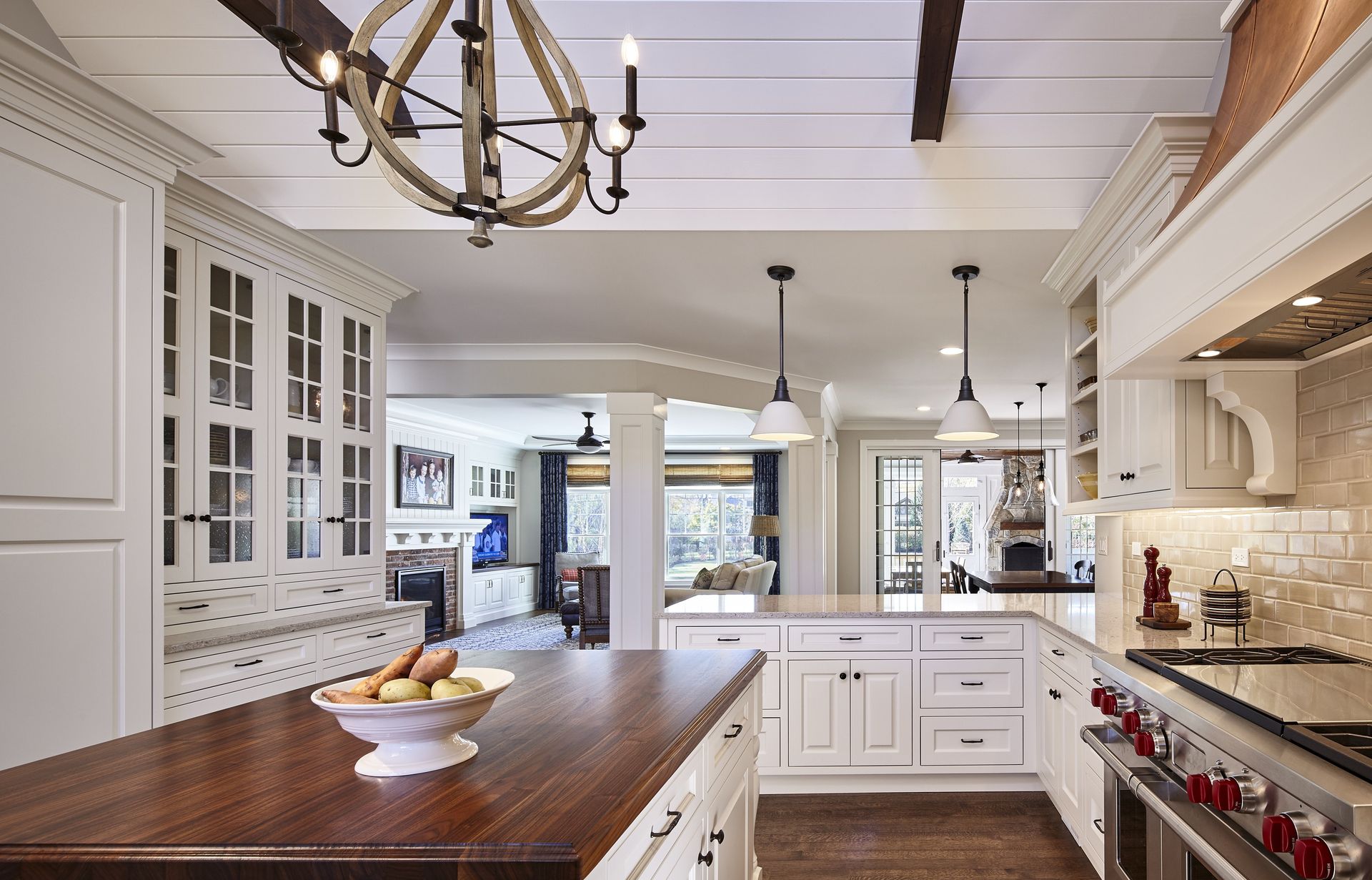 A kitchen with white cabinets and a wooden counter top