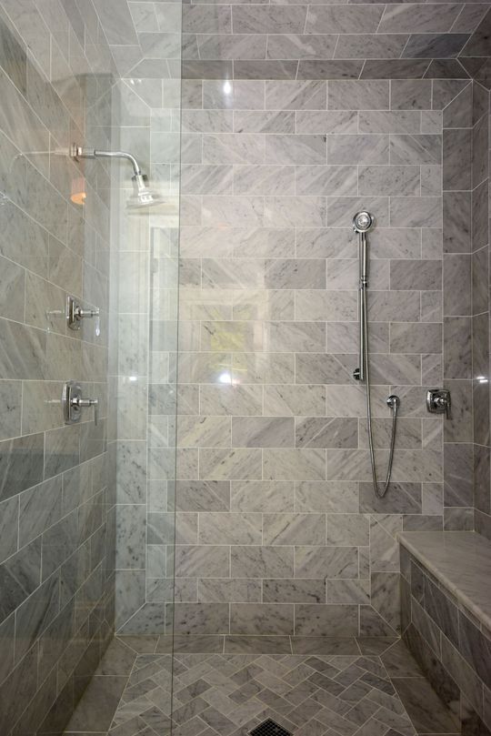 A bathroom with a walk in shower and a bench.