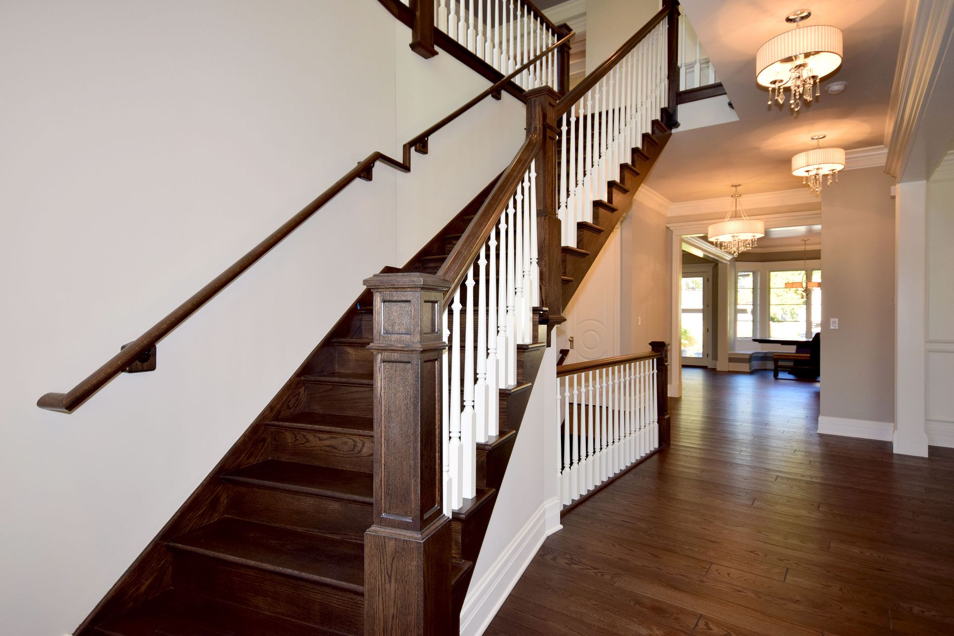 A wooden staircase with a white railing in a hallway.