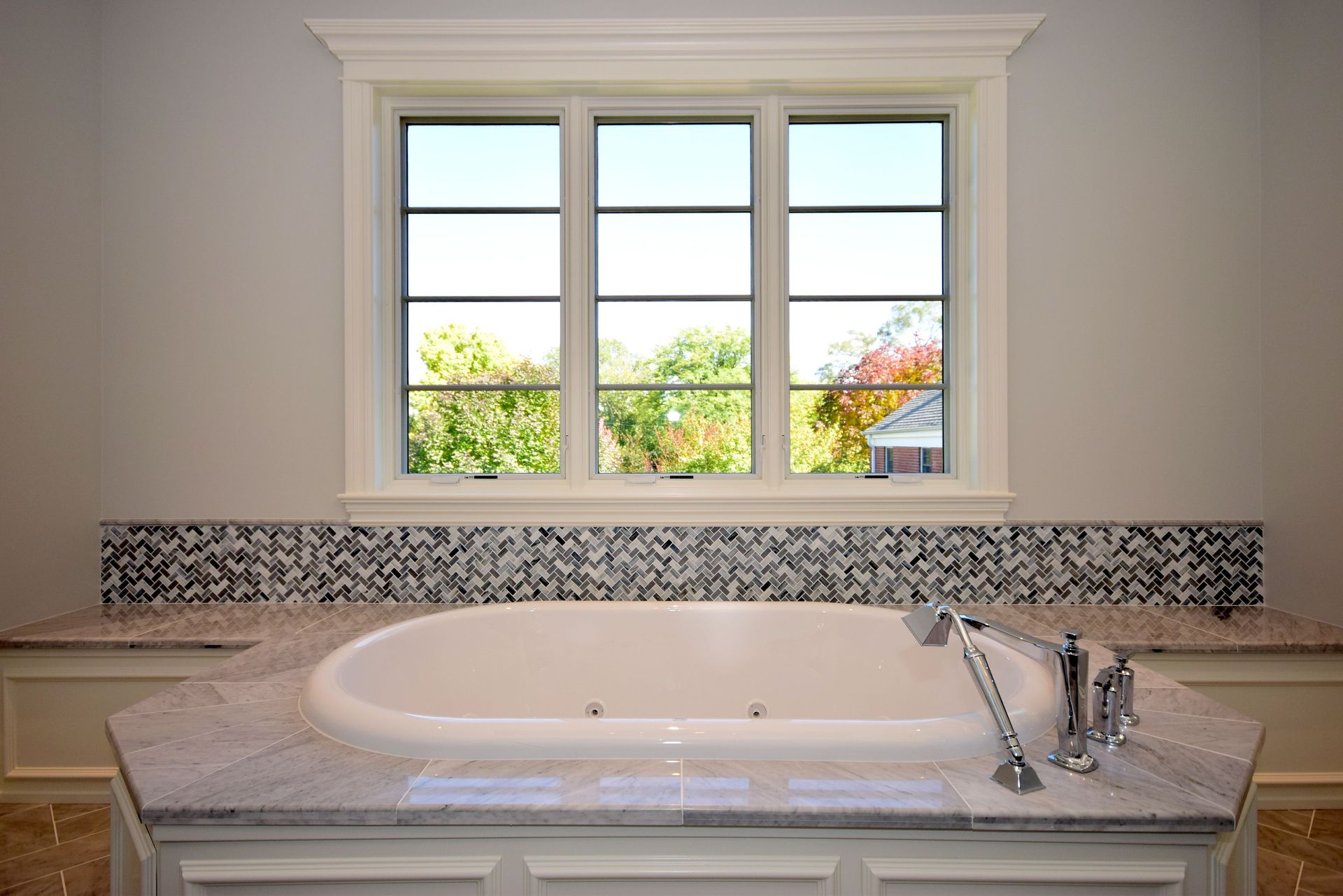 A bathroom with a jacuzzi tub and a window.