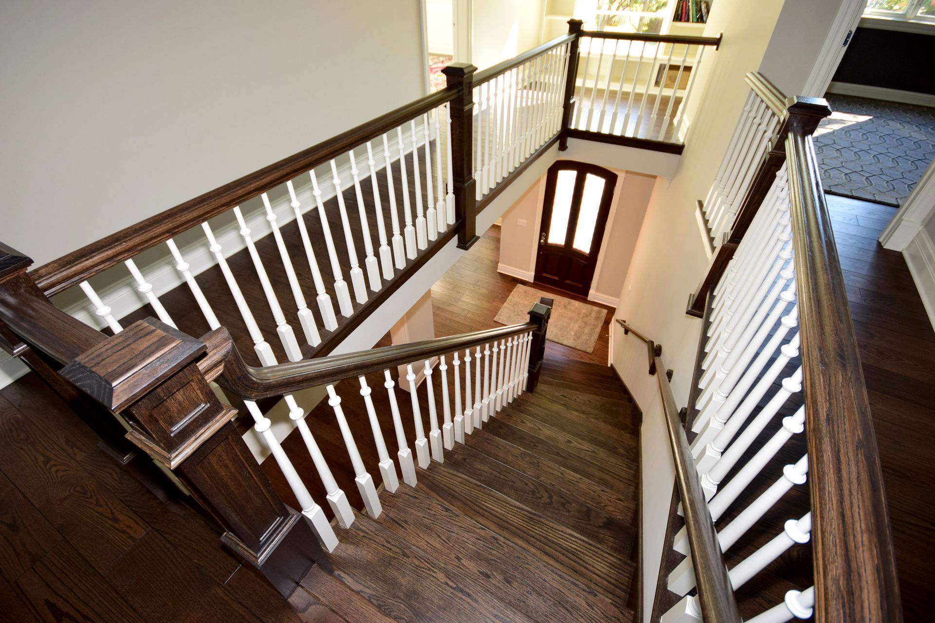 A staircase with a wooden railing and a white railing