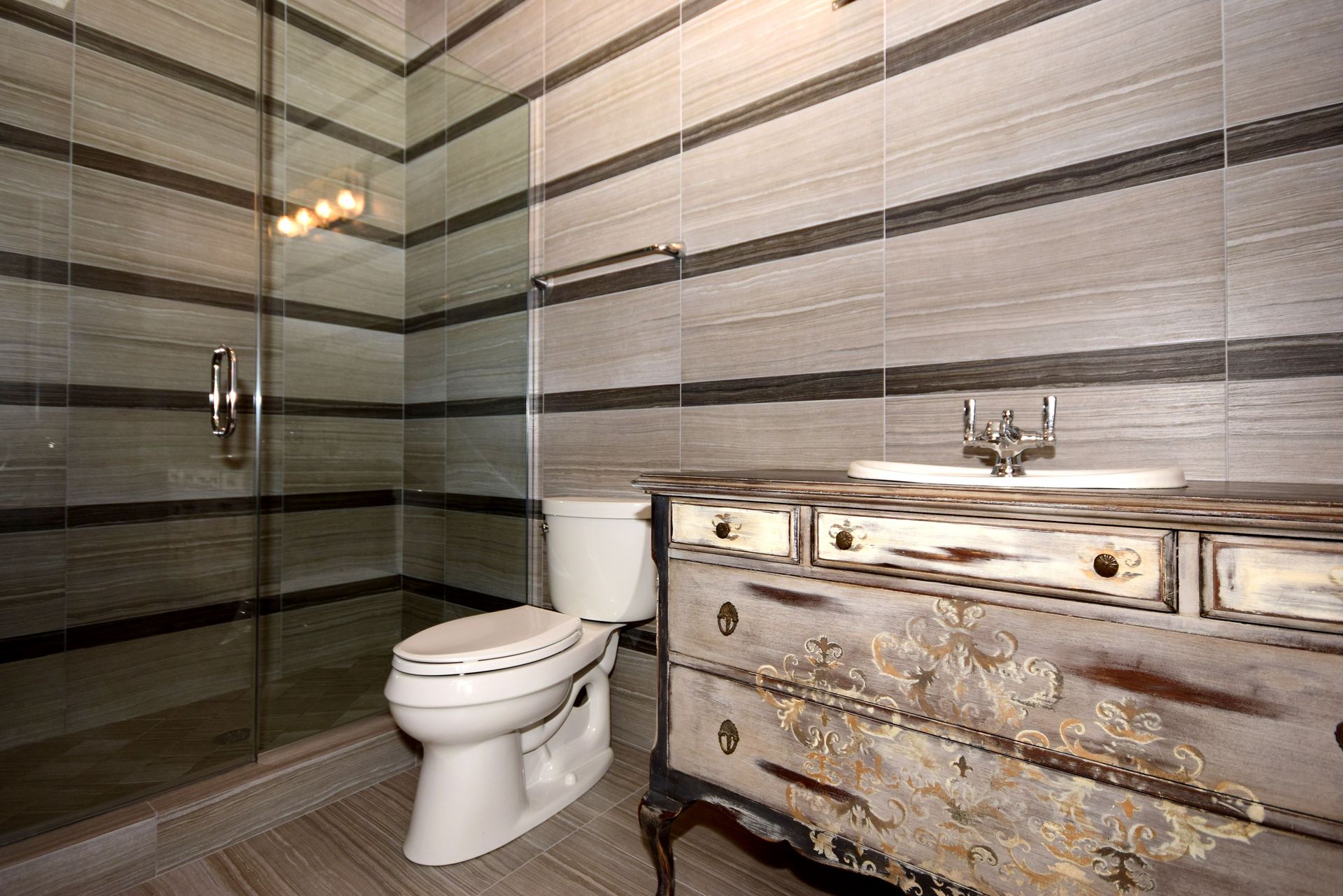 A bathroom with a toilet , sink and shower.