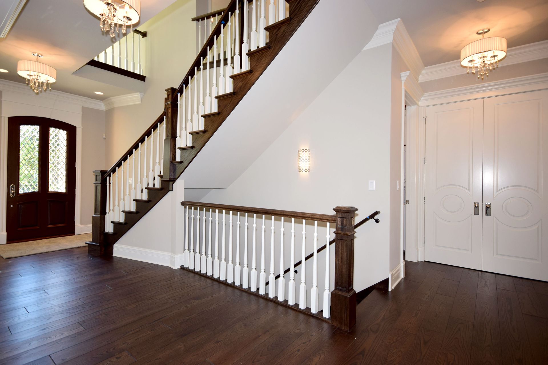 An empty hallway with a staircase and a door