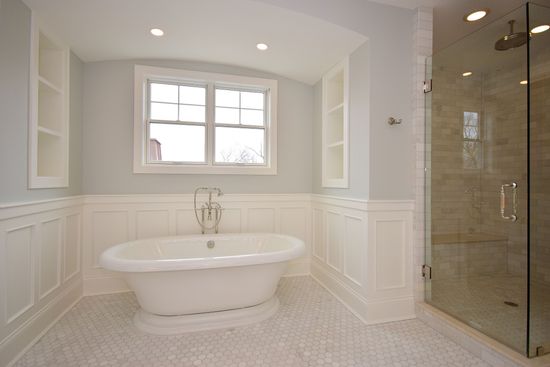 A bathroom with a tub , shower and window