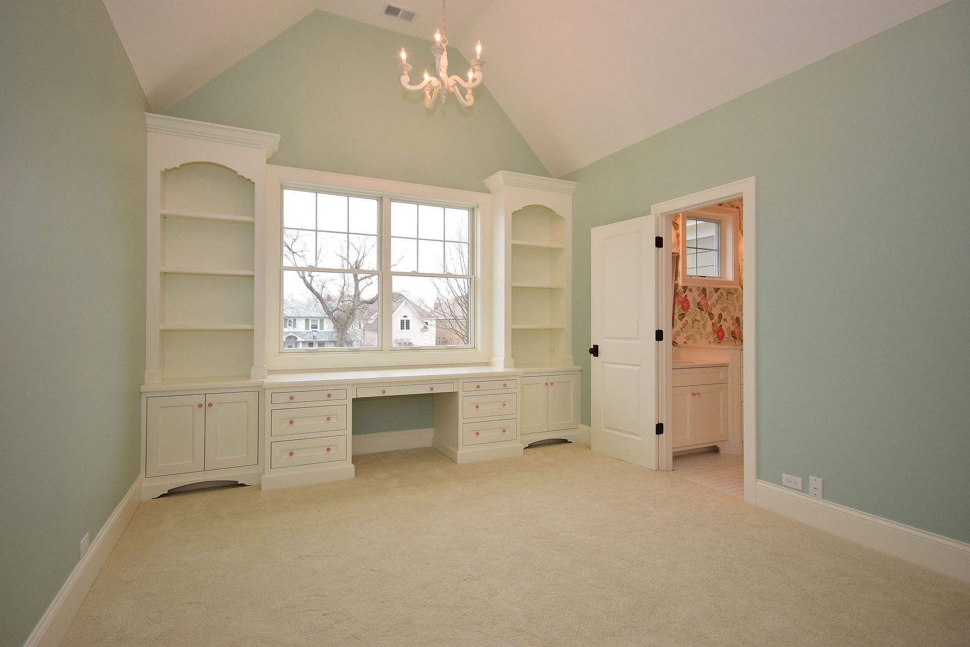 An empty room with a chandelier hanging from the ceiling