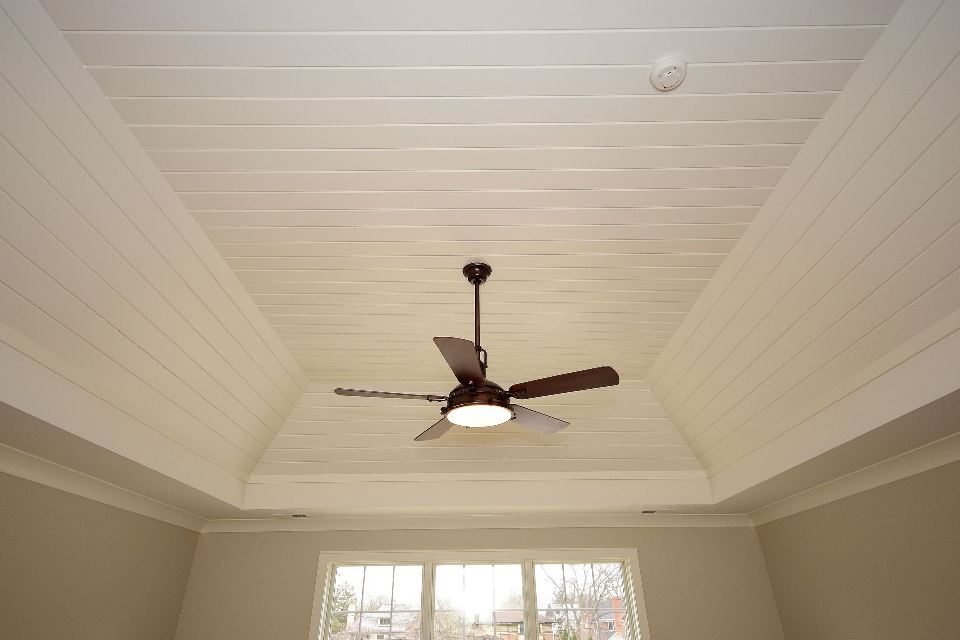 A ceiling fan is hanging from the ceiling of a room