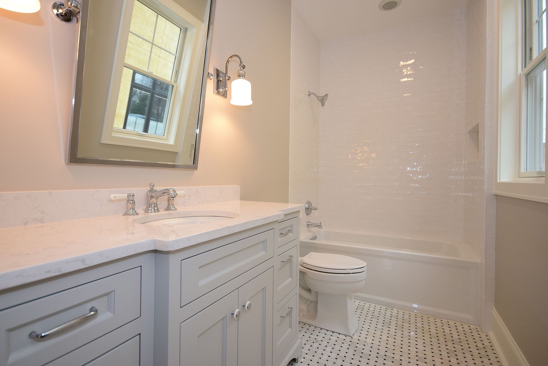 A bathroom with a sink , toilet , bathtub and mirror.