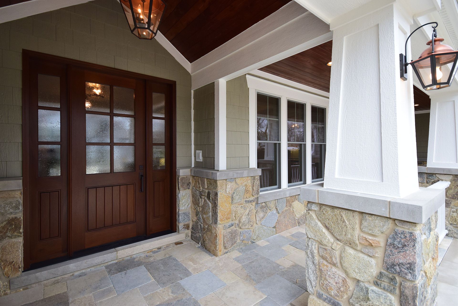 The front door of a house with a lantern hanging from the ceiling.