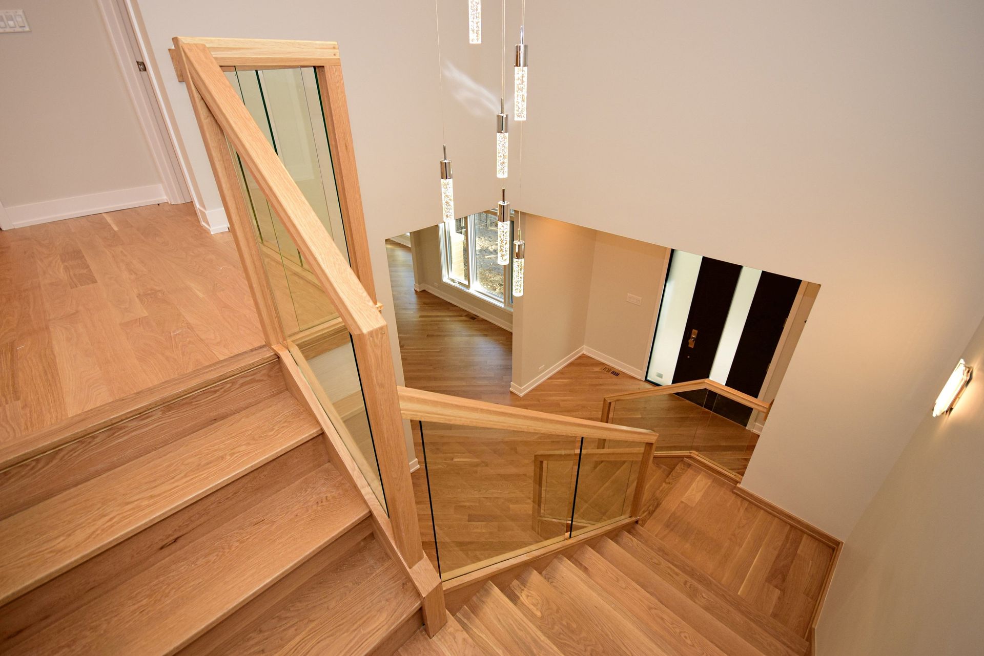 A wooden staircase with a glass railing in a house