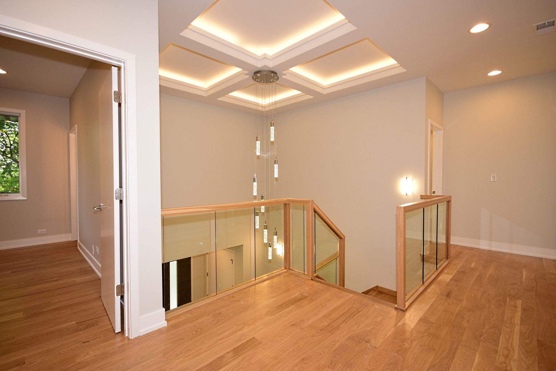 There is a staircase with a glass railing in the middle of the room.