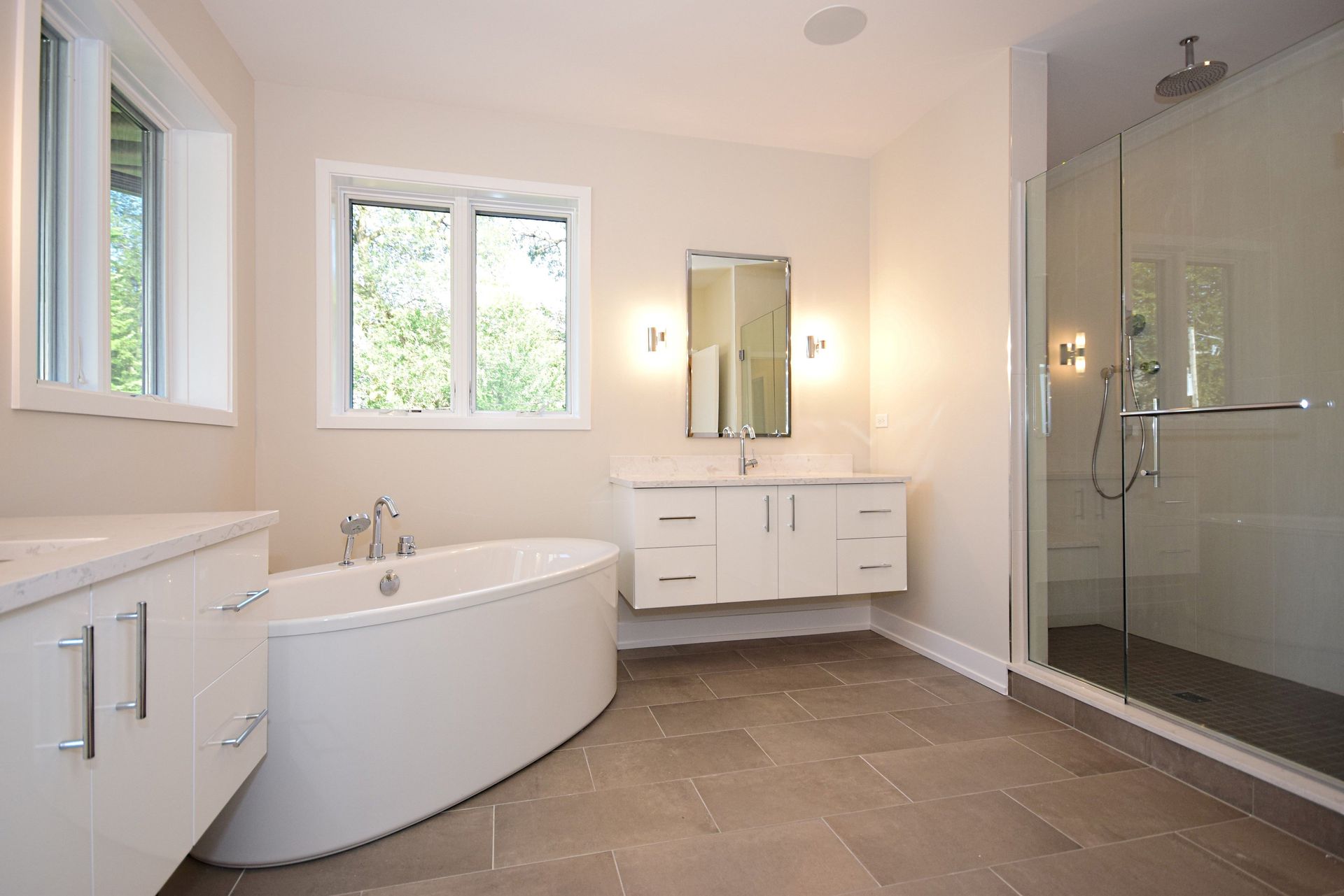 A bathroom with a tub , sink , mirror and shower.