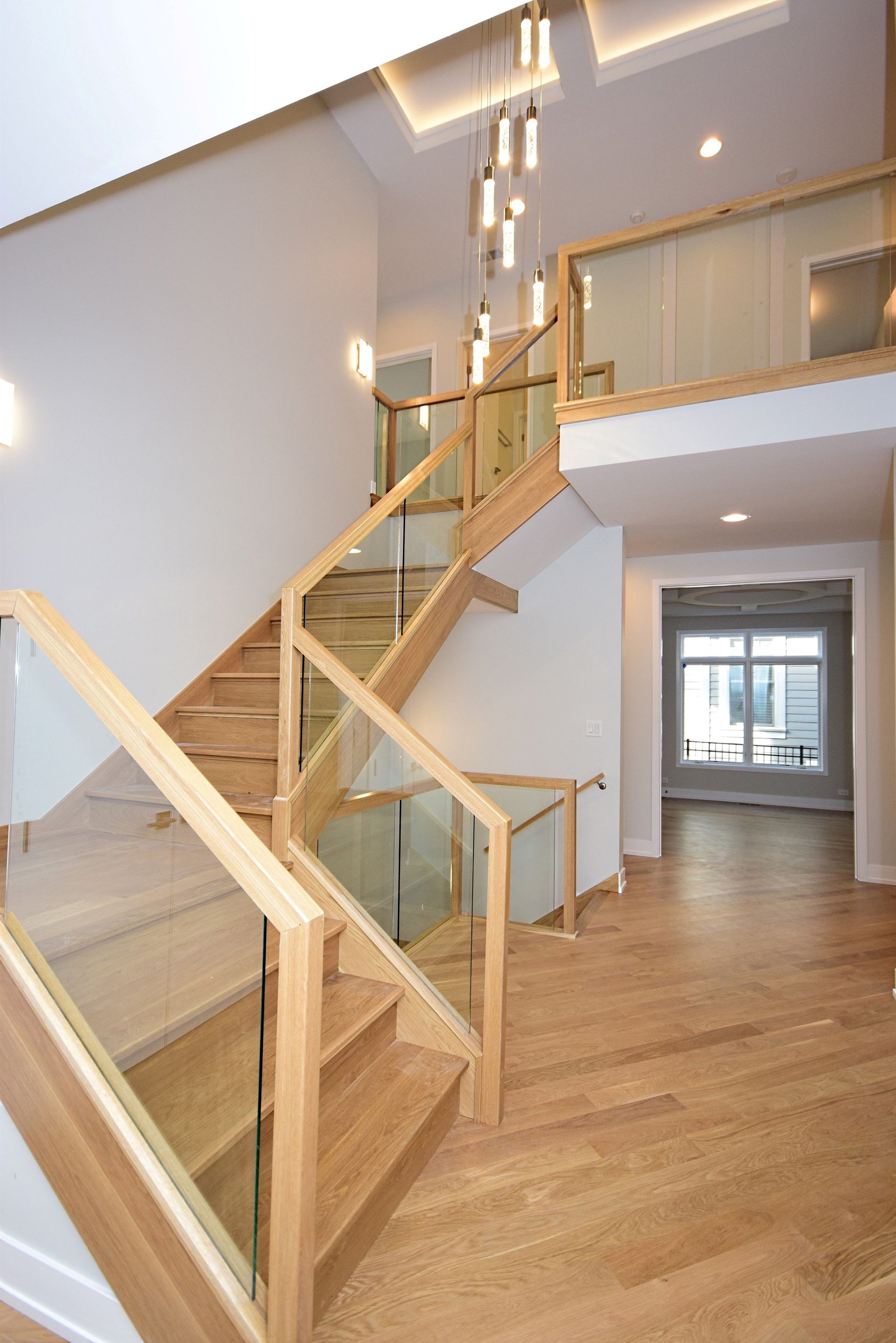 A wooden staircase with a glass railing in a house