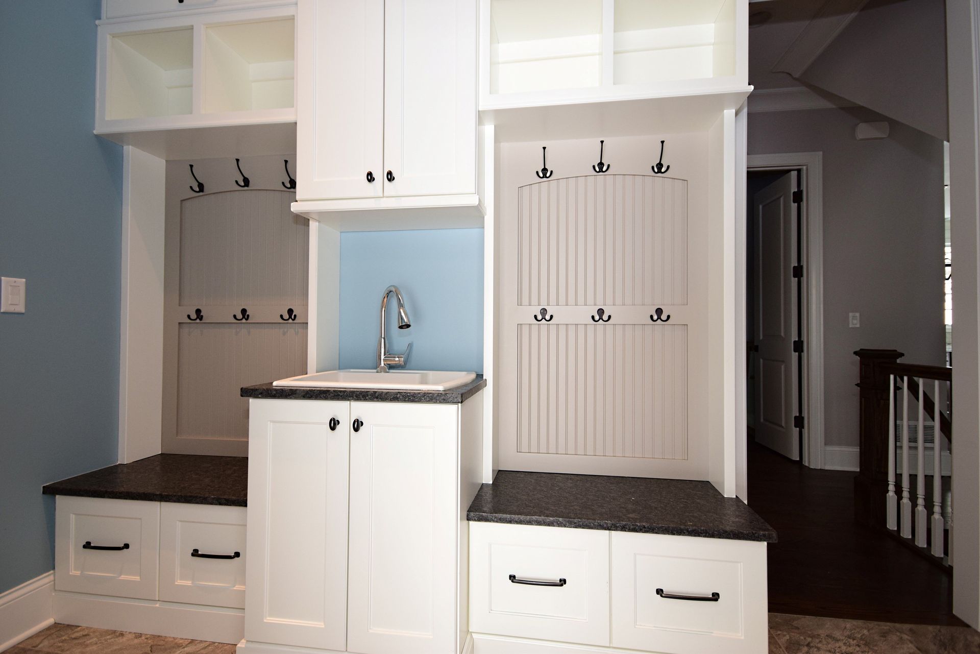 A kitchen with white cabinets and a sink