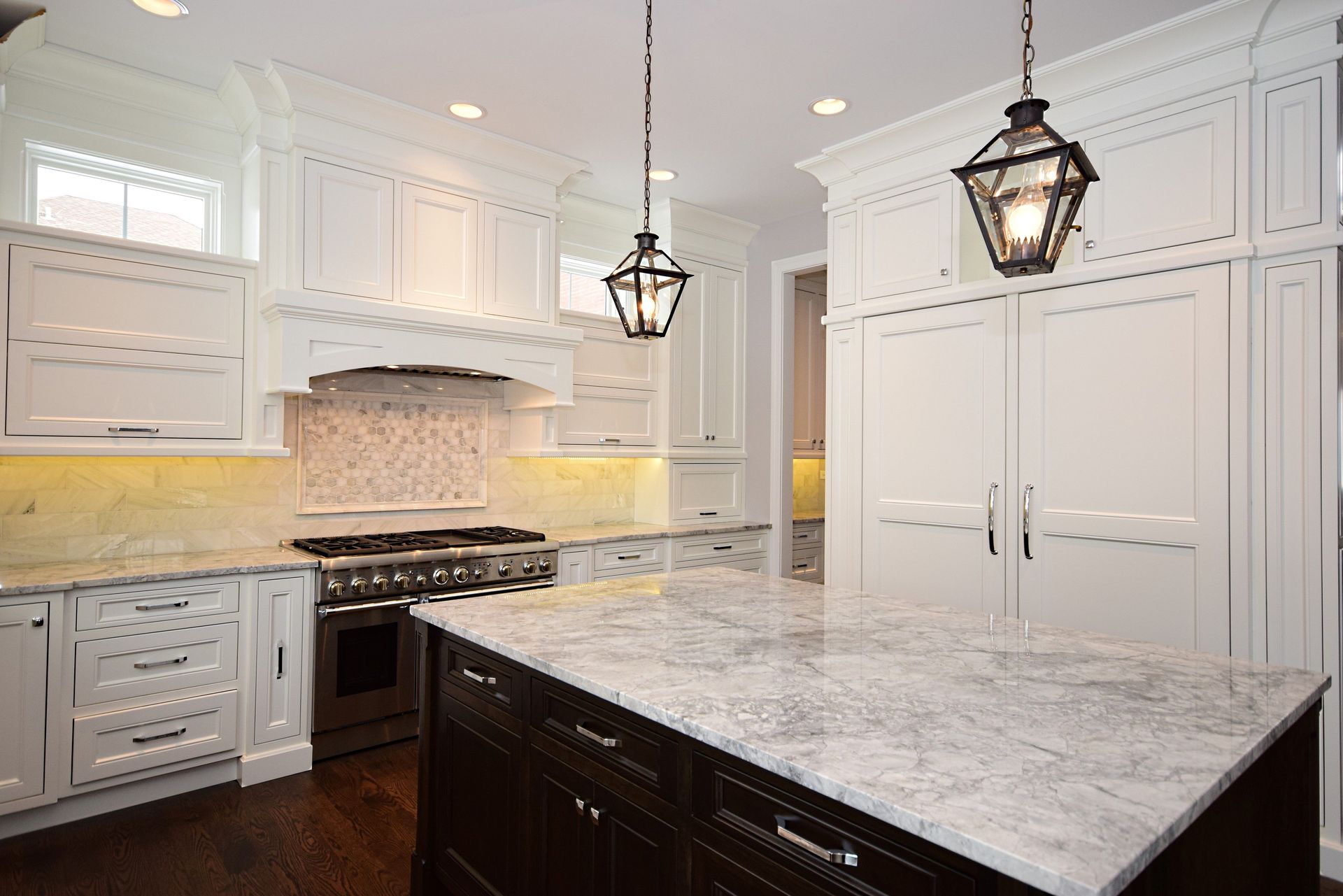 A kitchen with white cabinets and a large island in the middle.
