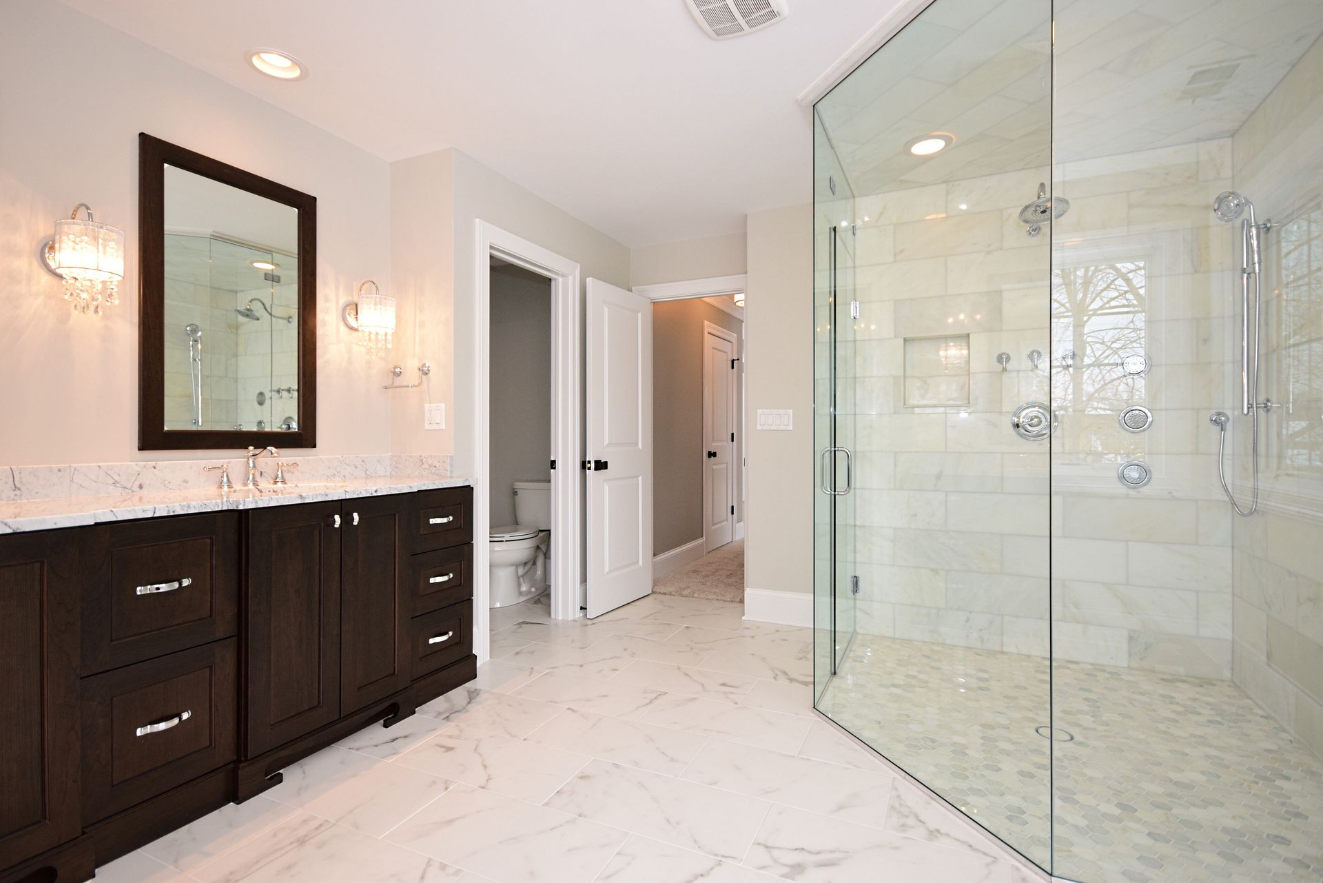 A bathroom with two sinks and a walk in shower.