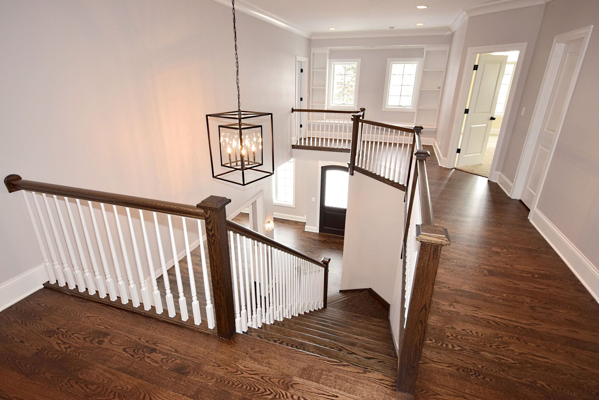 A staircase in a house with a chandelier hanging from the ceiling.