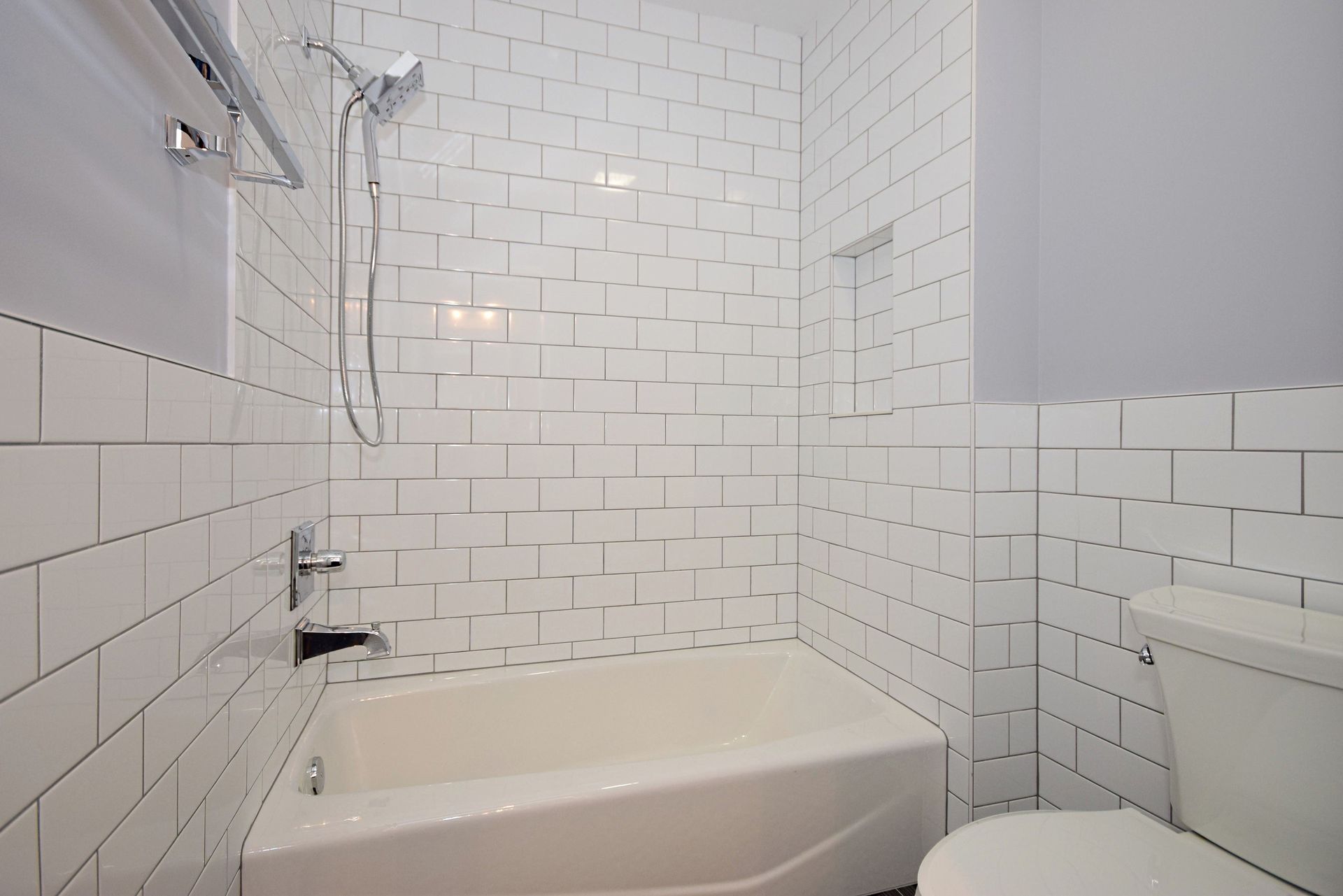 A bathroom with a tub , toilet and shower.