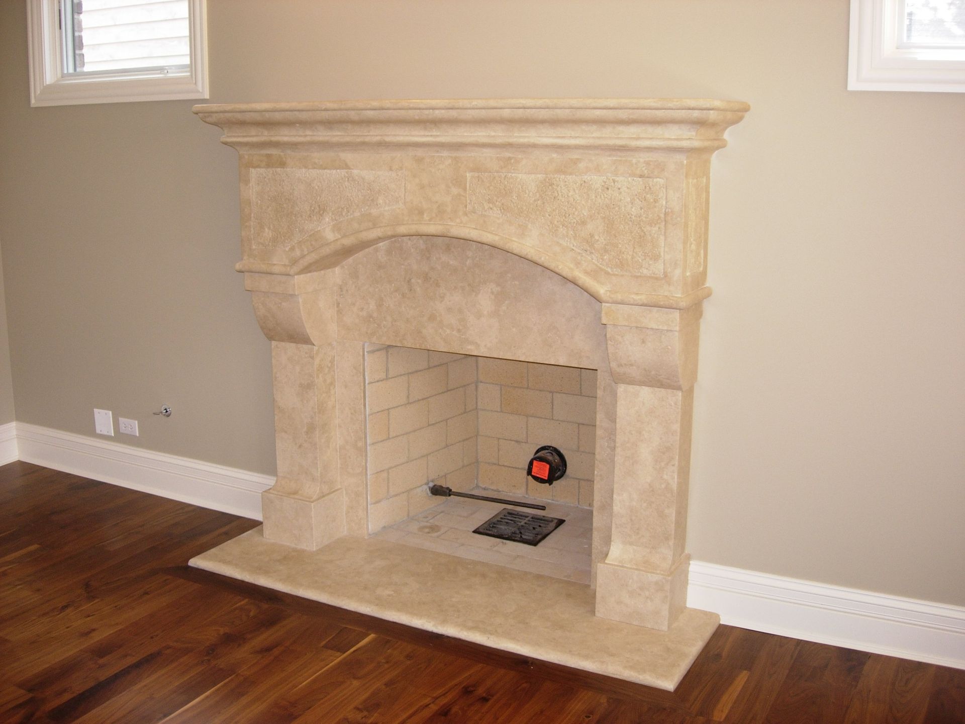 A fireplace in an empty room with a wooden floor