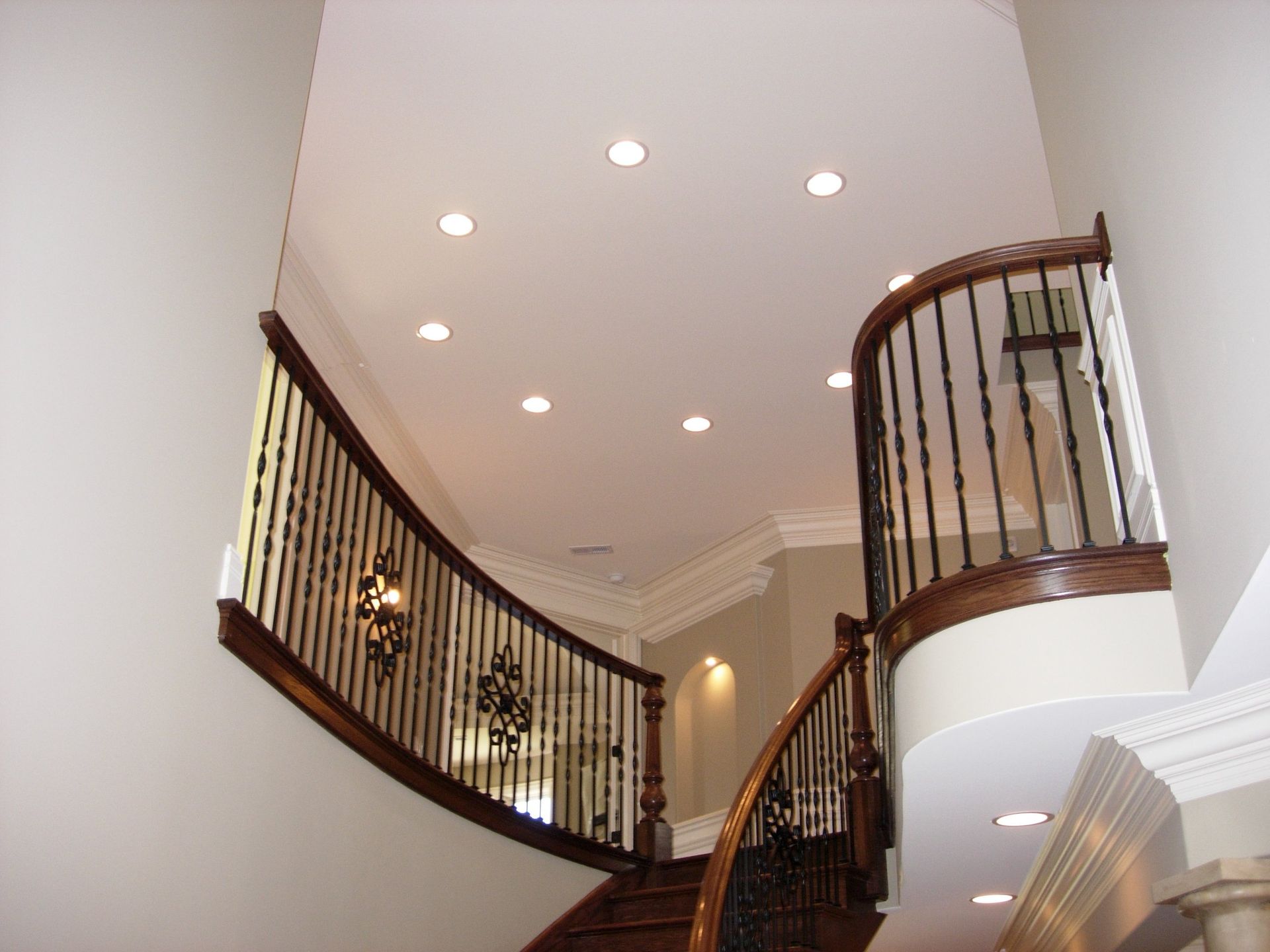 A curved staircase with a wrought iron railing in a house